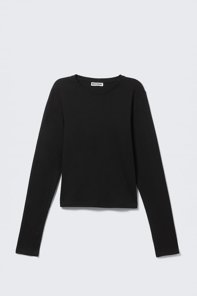Un top nero a maniche lunghe è rivolto verso il FRONTE, caratterizzato da uno scollo rotondo, maniche lunghe e una texture a maglia leggermente a coste. Un'etichetta del marchio "WEEKDAY" bianca è visibile all'interno del collo. - 1
