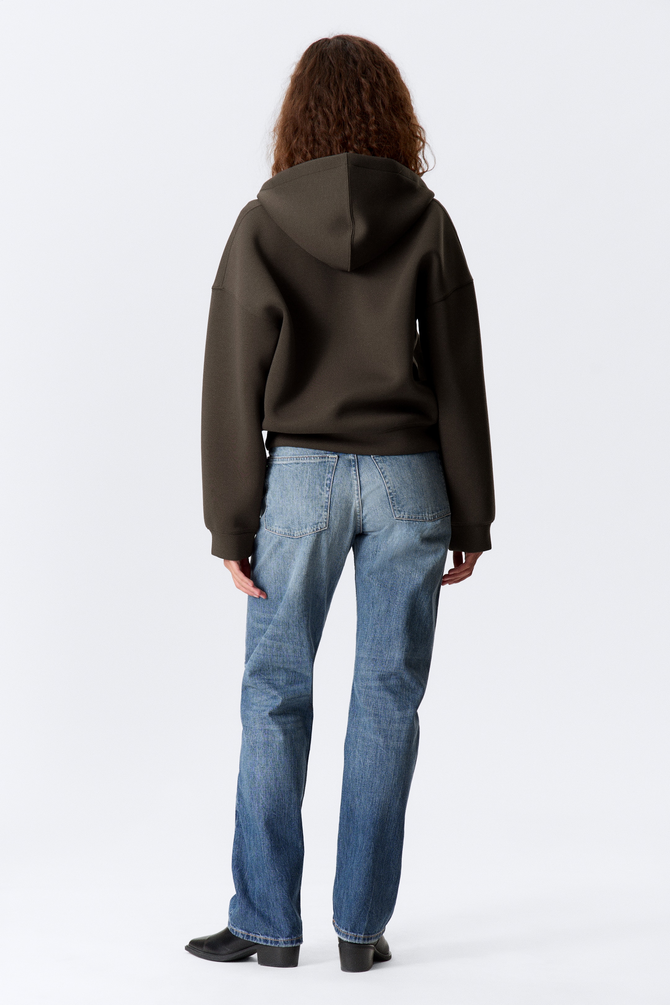Agrandir l'image: Un sweat à capuche vert olive foncé est présenté de dos, avec une coupe décontractée, des manches longues, et une capuche structurée avec une couture centrale.