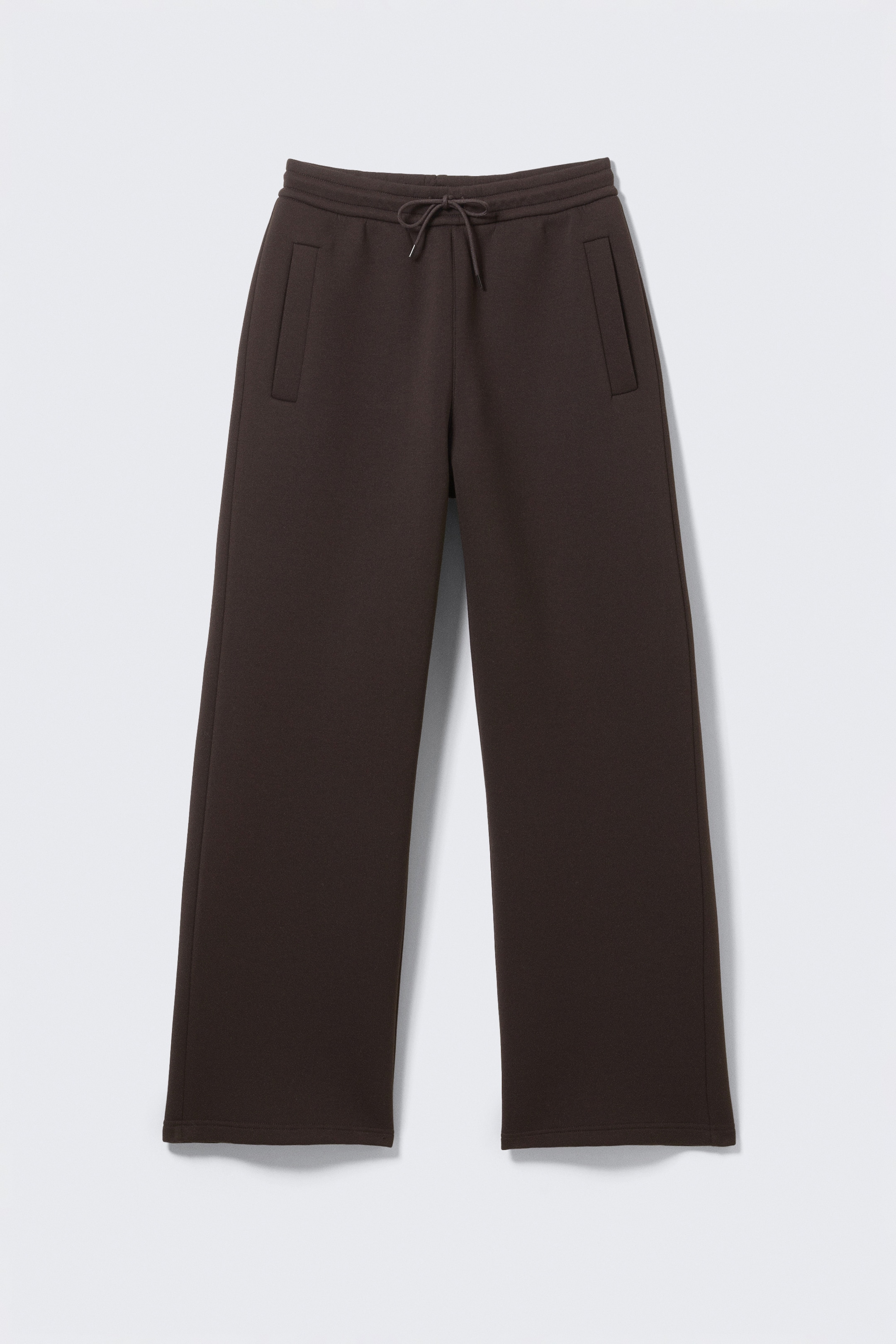 Grotere afbeelding bekijken: VOORAANZICHT van donkerbruine loose-fit joggingbroek, gemaakt van een dik scuba-materiaal, met een elastische tailleband met trekkoord en een gestrikt trekkoord, twee voorzakken met bies en een ontspannen silhouet.