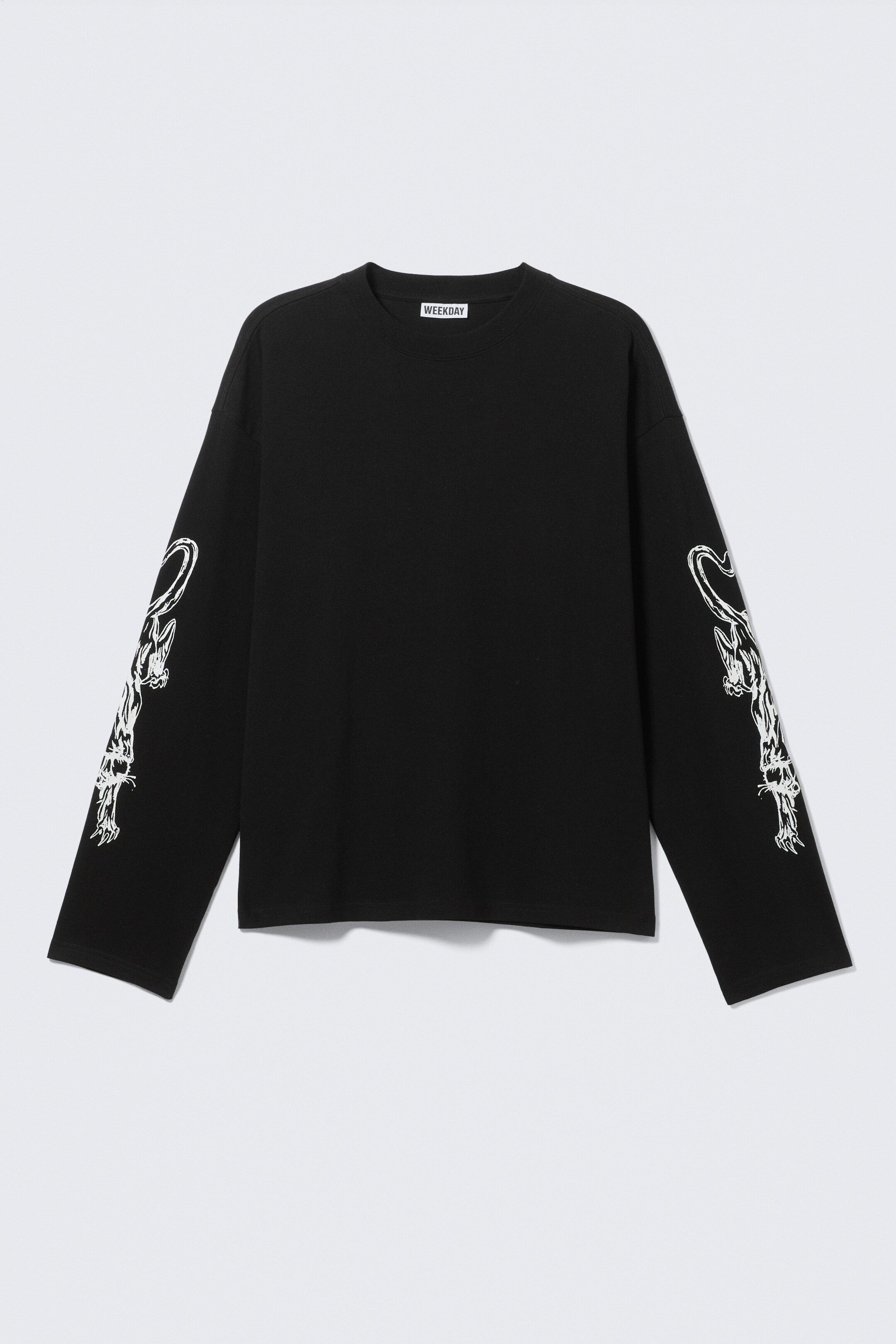 Vezi imaginea mai mare: Un tricou negru cu mânecă lungă este orientat frontal, prezentând o croială boxy, regulară și un gât rotund, cu margine nervurată. Grafice stilizate cu animale albe decorează părțile exterioare ale ambelor mâneci lungi.