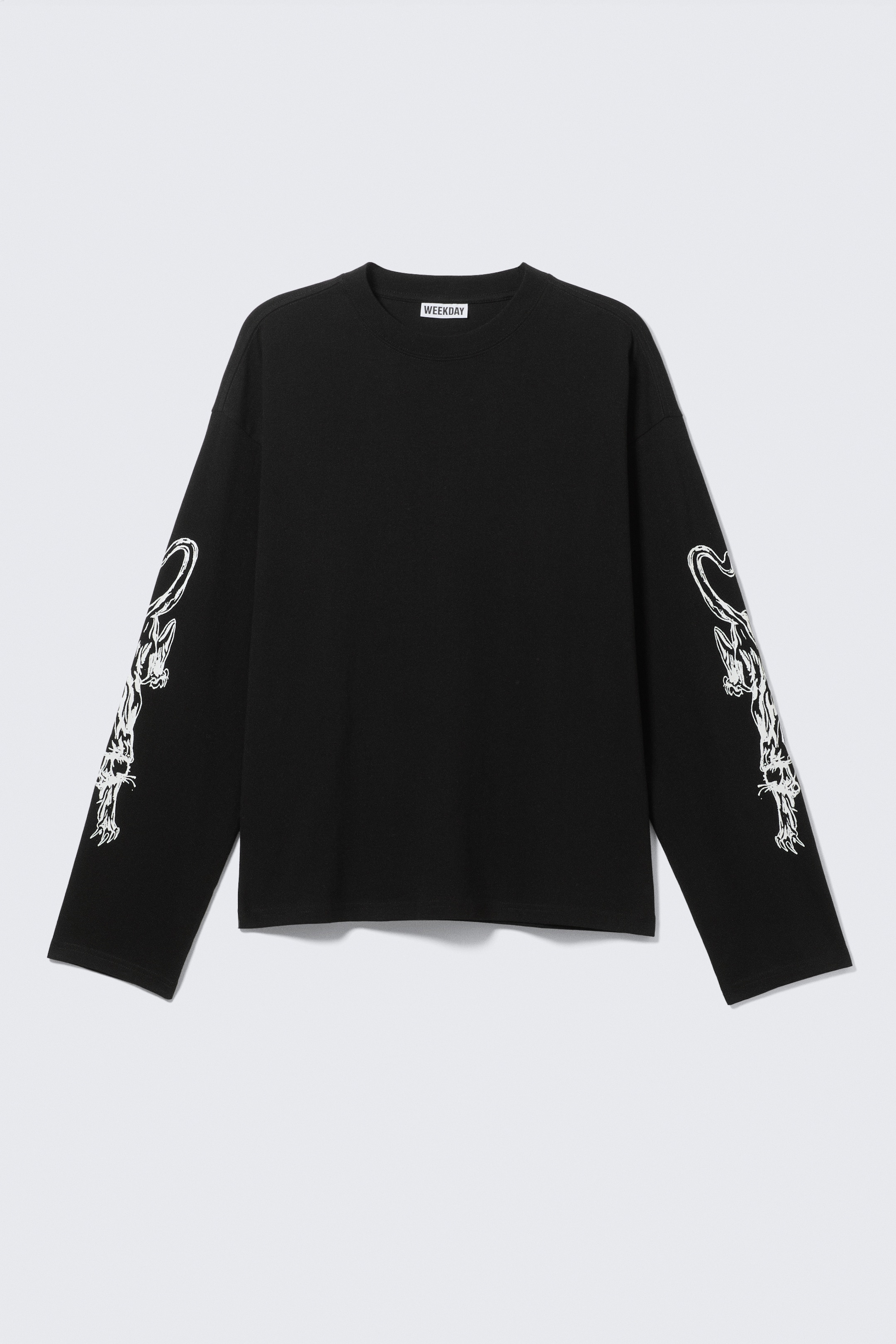 Agrandir l'image: Un T-shirt noir à manches longues est orienté vers l'avant, présentant une coupe régulière, ample, et un col rond côtelé. Des graphiques d'animaux stylisés en blanc détaillent les côtés extérieurs des deux manches longues.