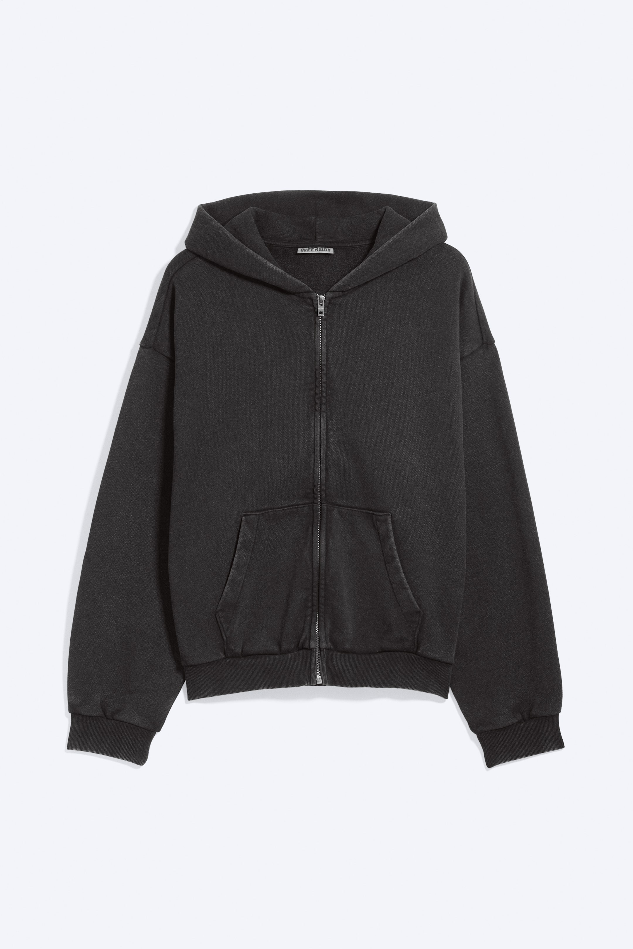 View larger image: A charcoal grey full-zip hoodie is shown from the front. It features a slightly faded finish, a full-length silver-toned zip, two front patch pockets, ribbed cuffs and a ribbed hem. A small "WEEKDAY" label is visible on the inside of the neck.