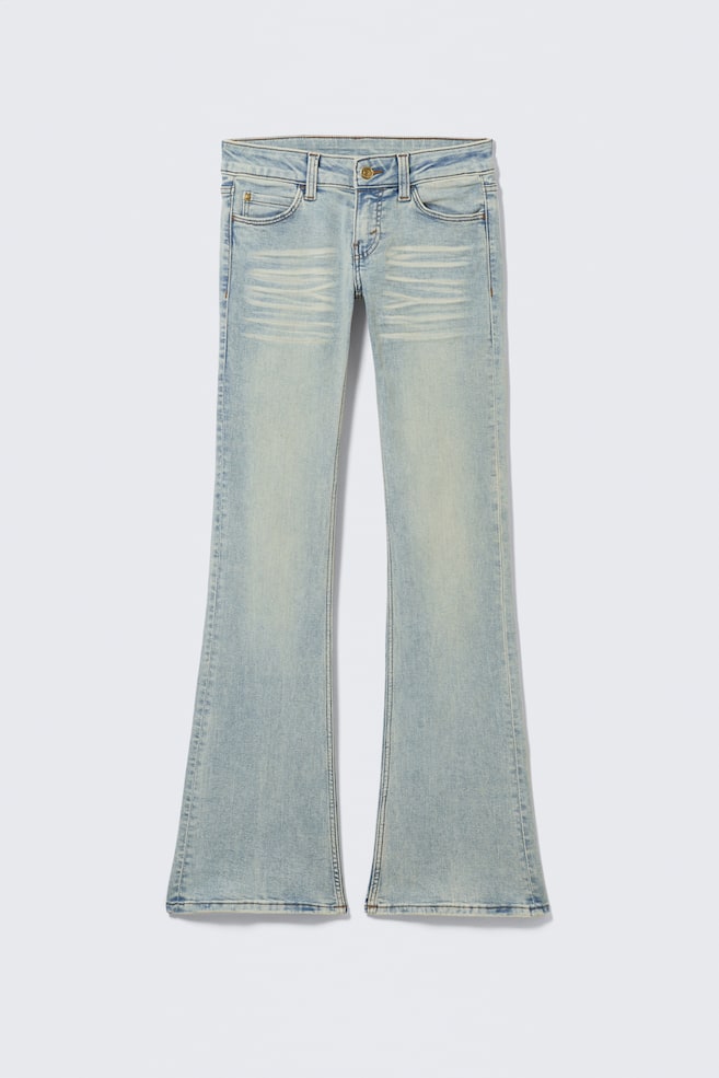 Vue de FACE du jean en denim bleu clair, présentant une coupe skinny qui s'évase en bas pour former une jambe bootcut. Ils affichent une taille basse, un design classique à 5 poches avec une fermeture éclair, et un délavage subtil sur le haut des cuisses. - 1