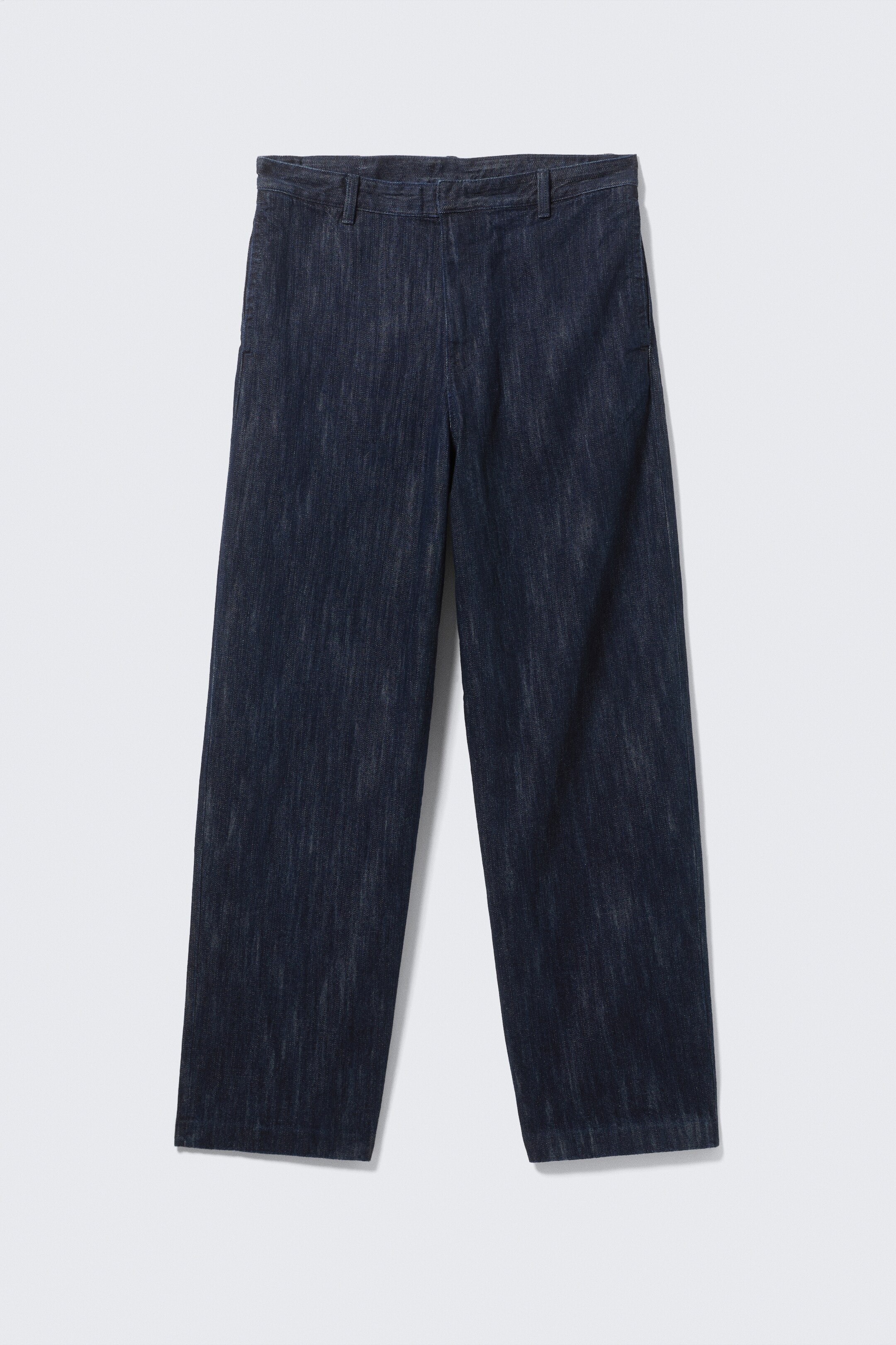 Agrandir l'image: Vue de face de pantalons bleu indigo foncé, avec un tissu texturé semblable à du denim et des striations verticales. Les pantalons présentent une ceinture plate avec des passants, des poches latérales discrètes et une coupe droite et décontractée.