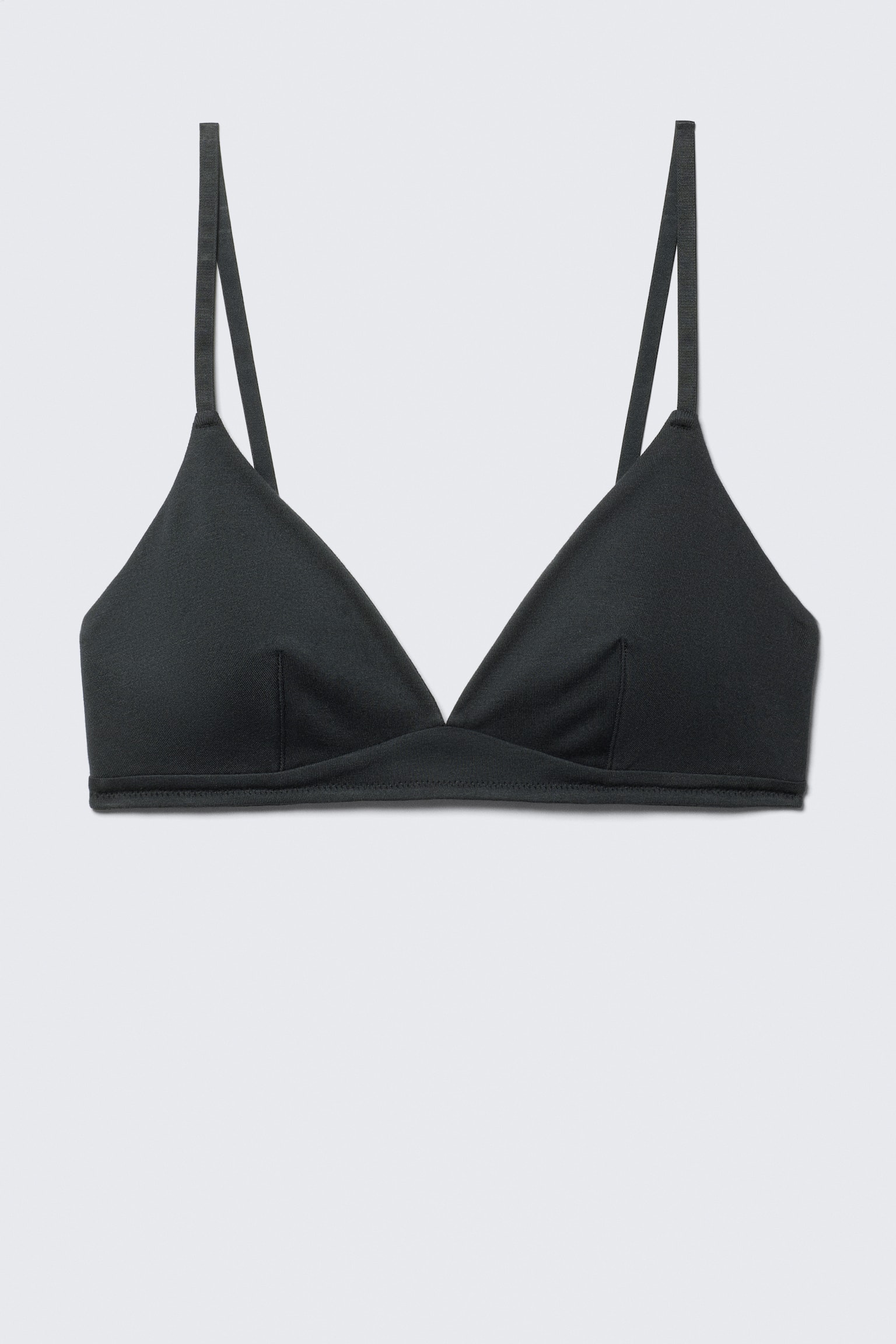 Czarny bralet jest prezentowany FRONT, z trójkątnymi miseczkami z pionowymi szwami i cienkimi ramiączkami spaghetti. Płaski, zszyty pasek tworzy podstawę ubrania.