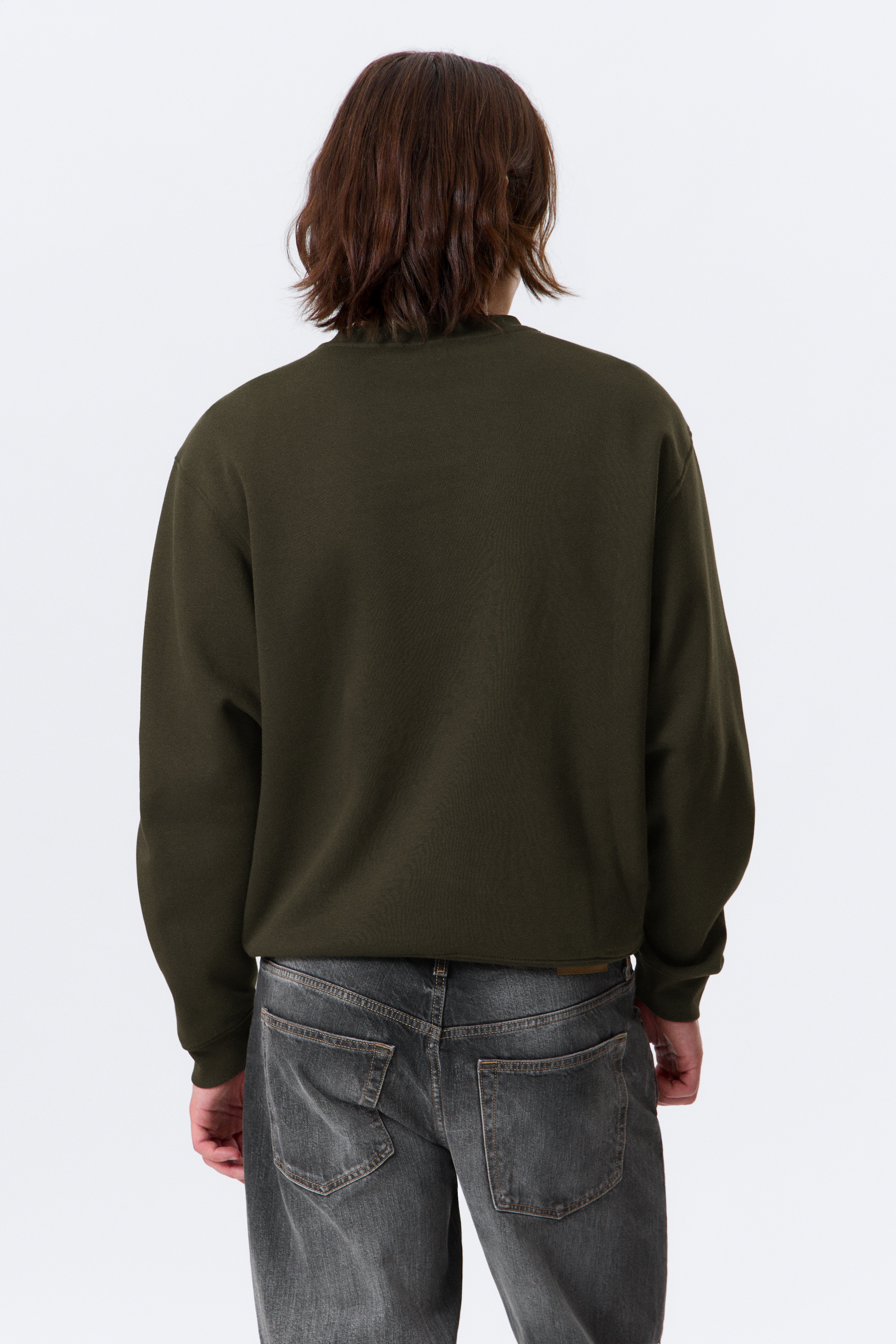 Größeres Bild anzeigen: Ein dunkelgrünes Sweatshirt mit Rundhalsausschnitt wird von hinten gezeigt. Es hat eine normale Passform mit leicht überschnittenen Schultern und gerippten Abschlüssen am Halsausschnitt, an den Bündchen und am Saum.