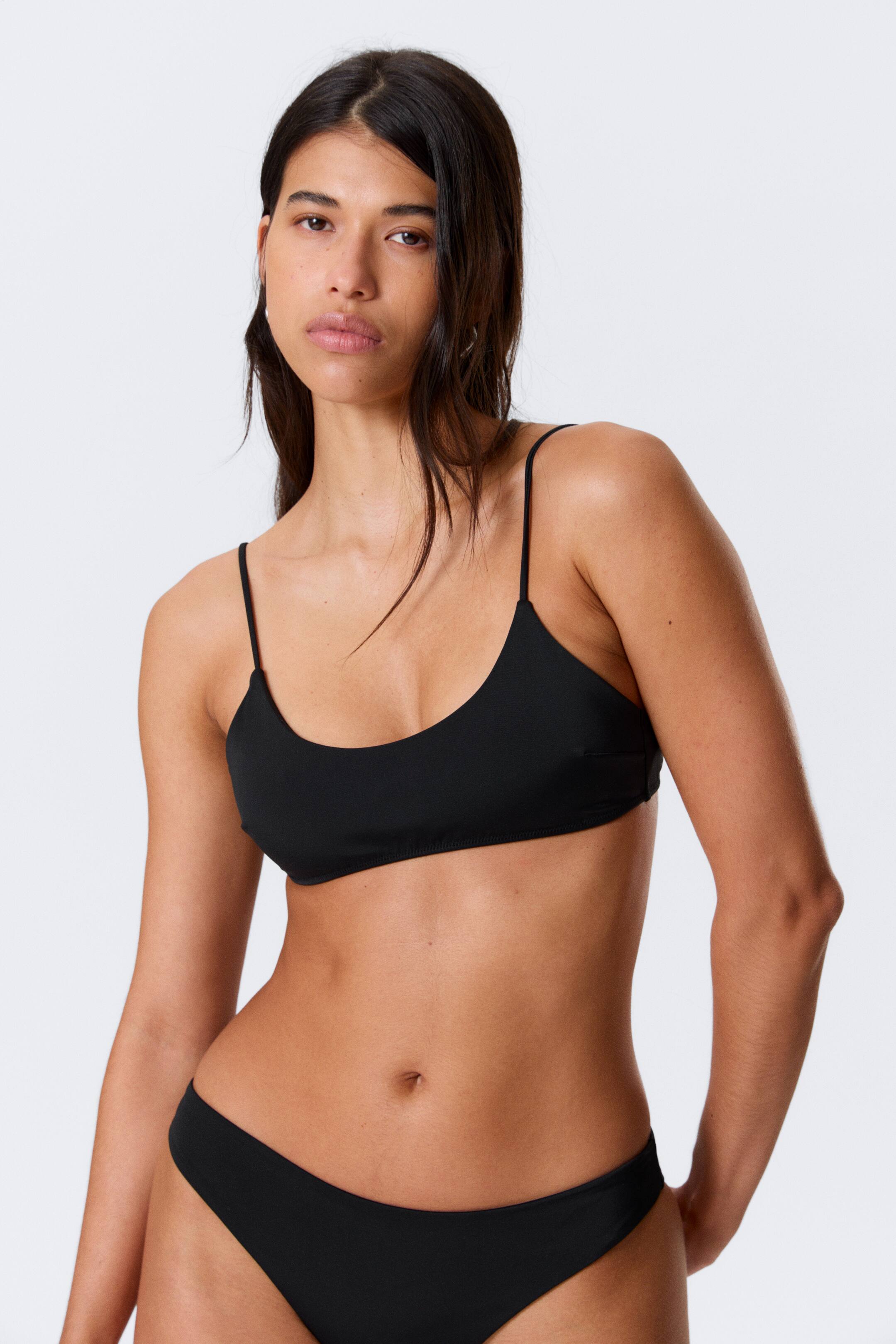 Größeres Bild anzeigen: Ein schwarzes Bikini-Set wird aus einer frontalen Perspektive präsentiert, mit einem Scoop-Neck-Top mit dünnen Spaghettiträgern und einem dazu passenden hochgeschnittenen Unterteil, das eng anliegt.