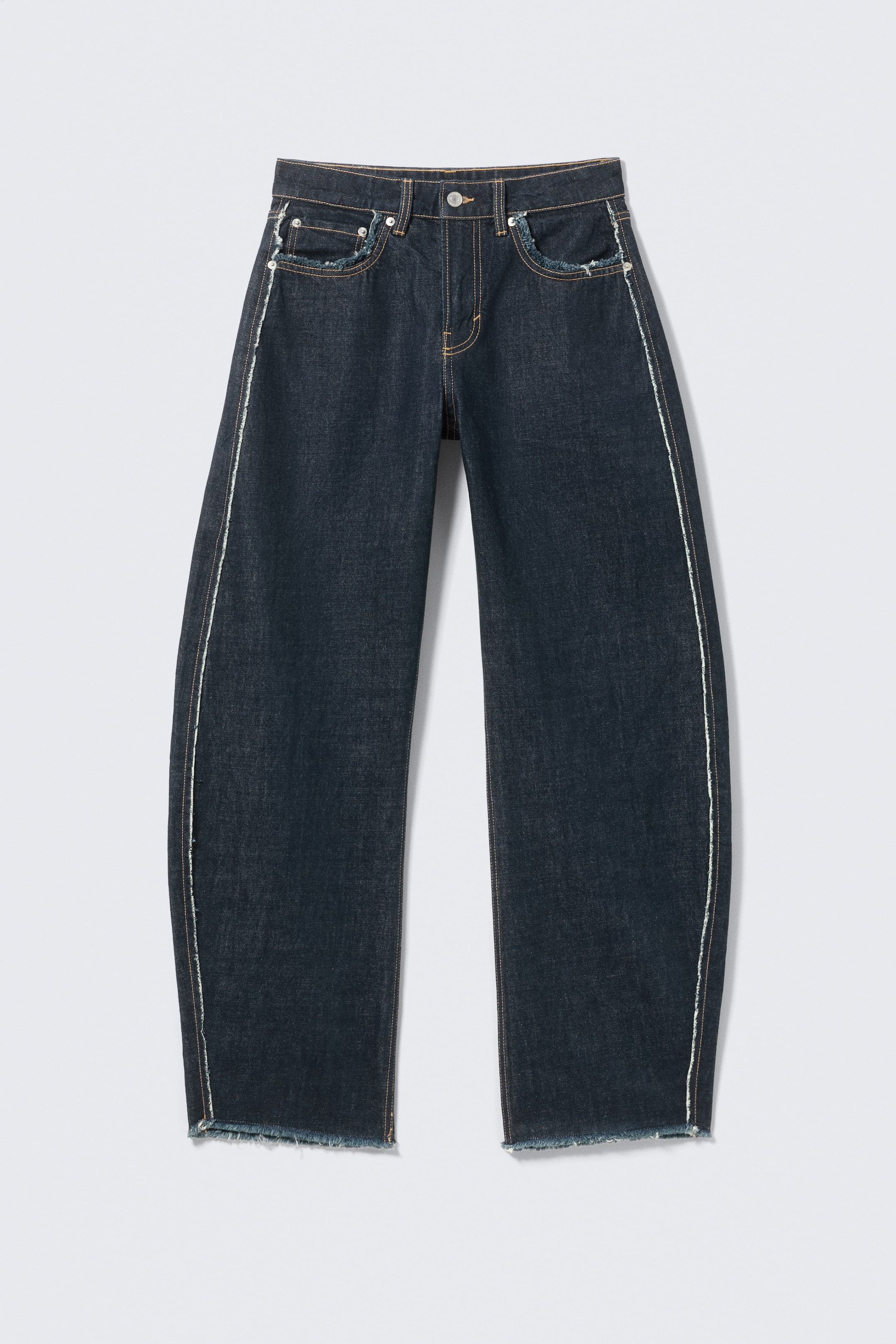 Ver imagem maior: Um par de jeans em índigo escuro é apresentado pela FRONT, com cintura média e pernas barril esculpidas. Detalha-se com um design clássico de cinco bolsos, fecho de correr com botão e bordas proeminentes e desfiadas ao longo das costuras laterais externas, aberturas dos bolsos frontais e bainhas.