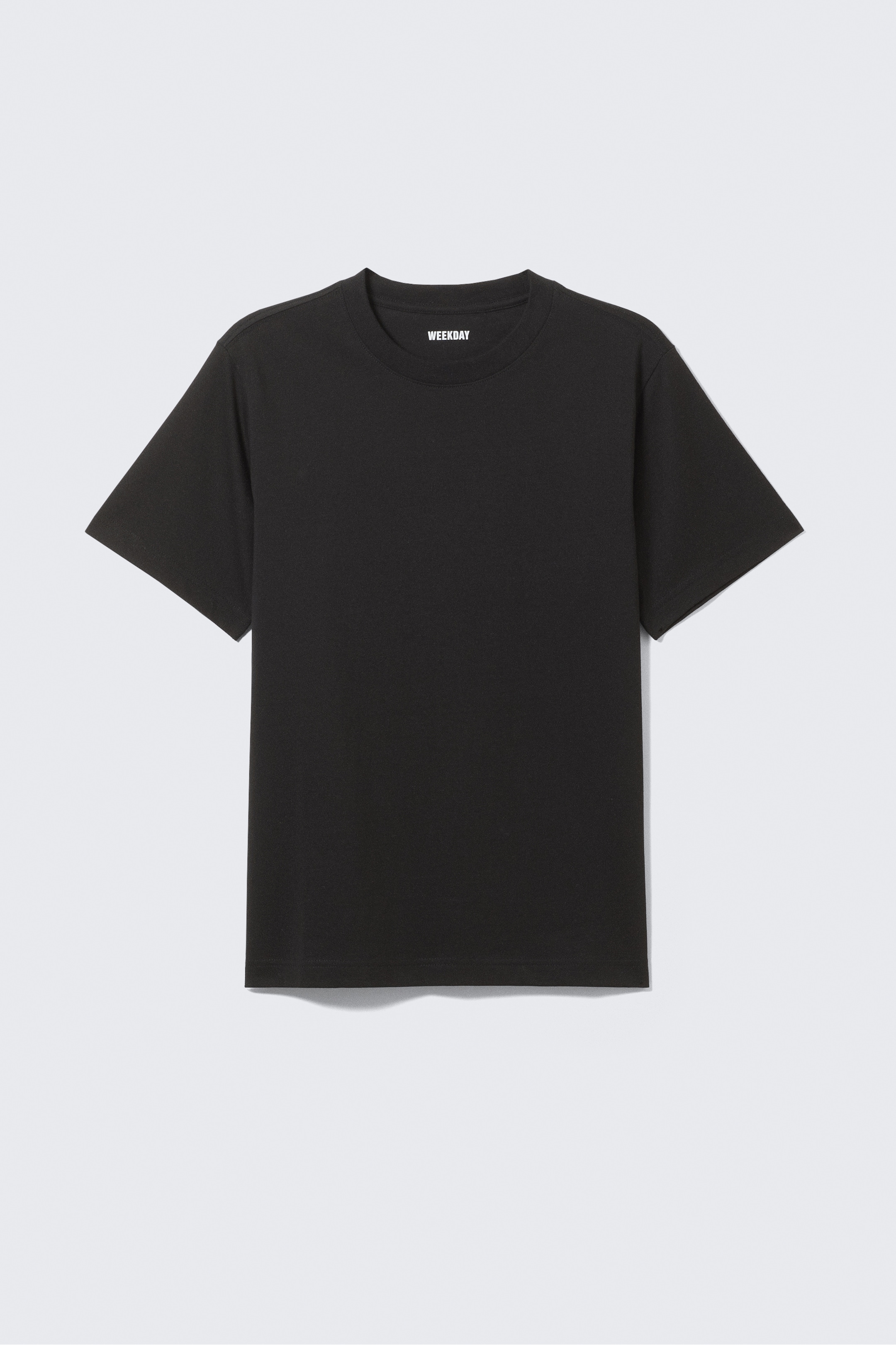 Grösseres Bild ansehen: Ein schwarzes T-Shirt ist nach VORNE ausgerichtet, mit einem Rundhalsausschnitt, kurzen, breiten Ärmeln und einer lockeren, kastigen Passform. Ein weißes 'WEEKDAY'-Etikett ist am inneren hinteren Halsbereich sichtbar.