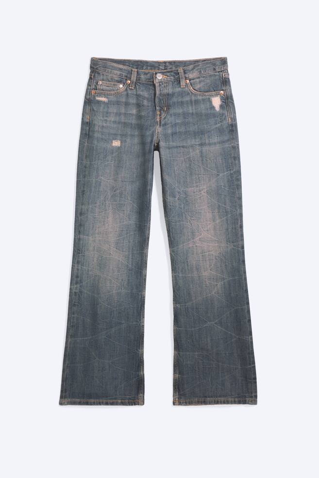Um par de jeans bootcut de cintura descida e corte descontraÃ­do, em lavagem azul desbotada, Ã© apresentado de frente, com um padrÃ£o texturizado enrugado por toda a peÃ§a e pequenos detalhes desgastados junto aos bolsos. Os jeans exibem um design clÃ¡ssico de cinco bolsos, com perna ligeiramente acampanada. - 1