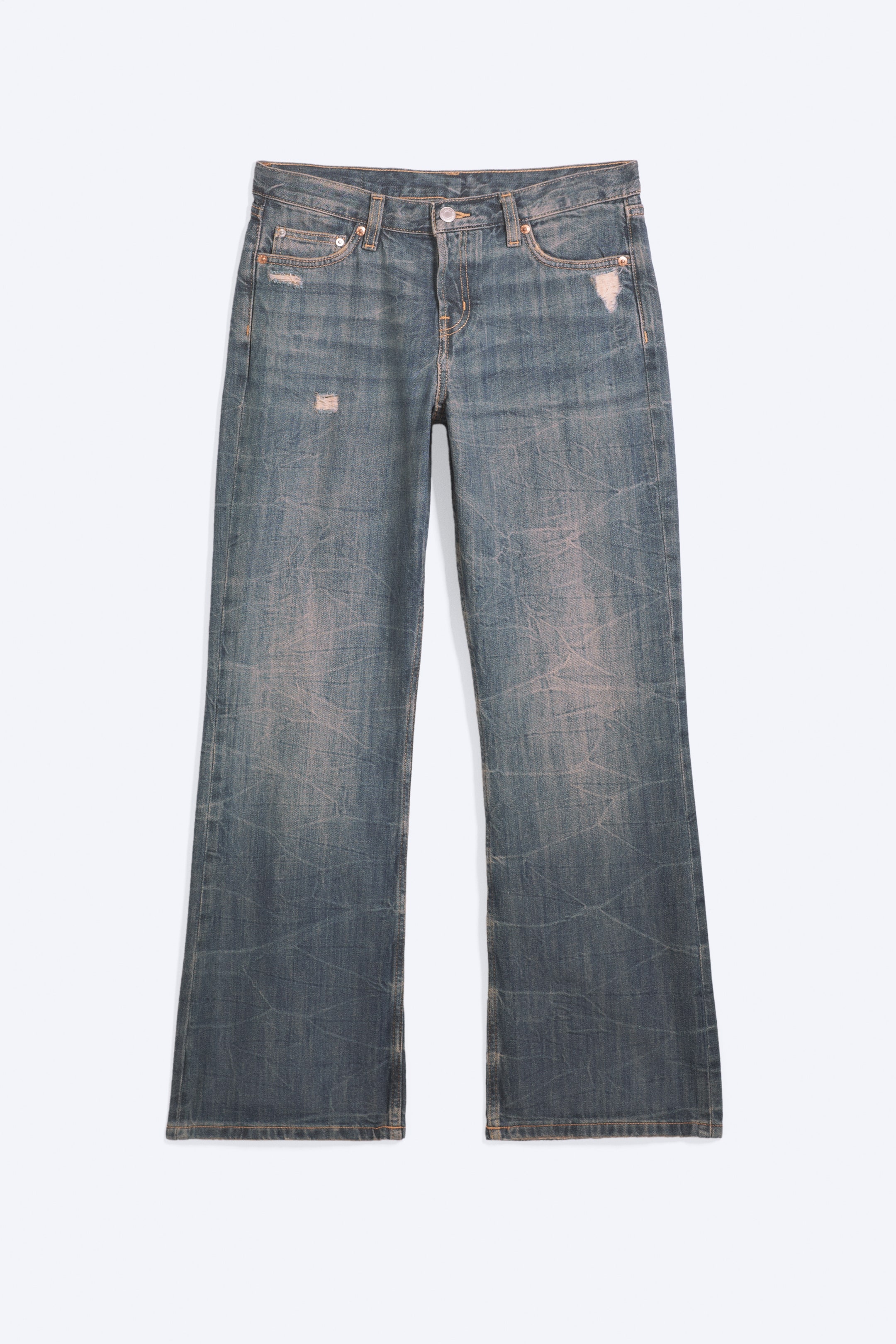Ver imagen más grande: Se muestra por delante un par de vaqueros bootcut de tiro bajo y corte relajado en un lavado azul descolorido, con un patrón arrugado texturizado en toda la prenda y pequeños detalles desgastados cerca de los bolsillos. Los vaqueros presentan el clásico diseño de cinco bolsillos y una pernera ligeramente acampanada.