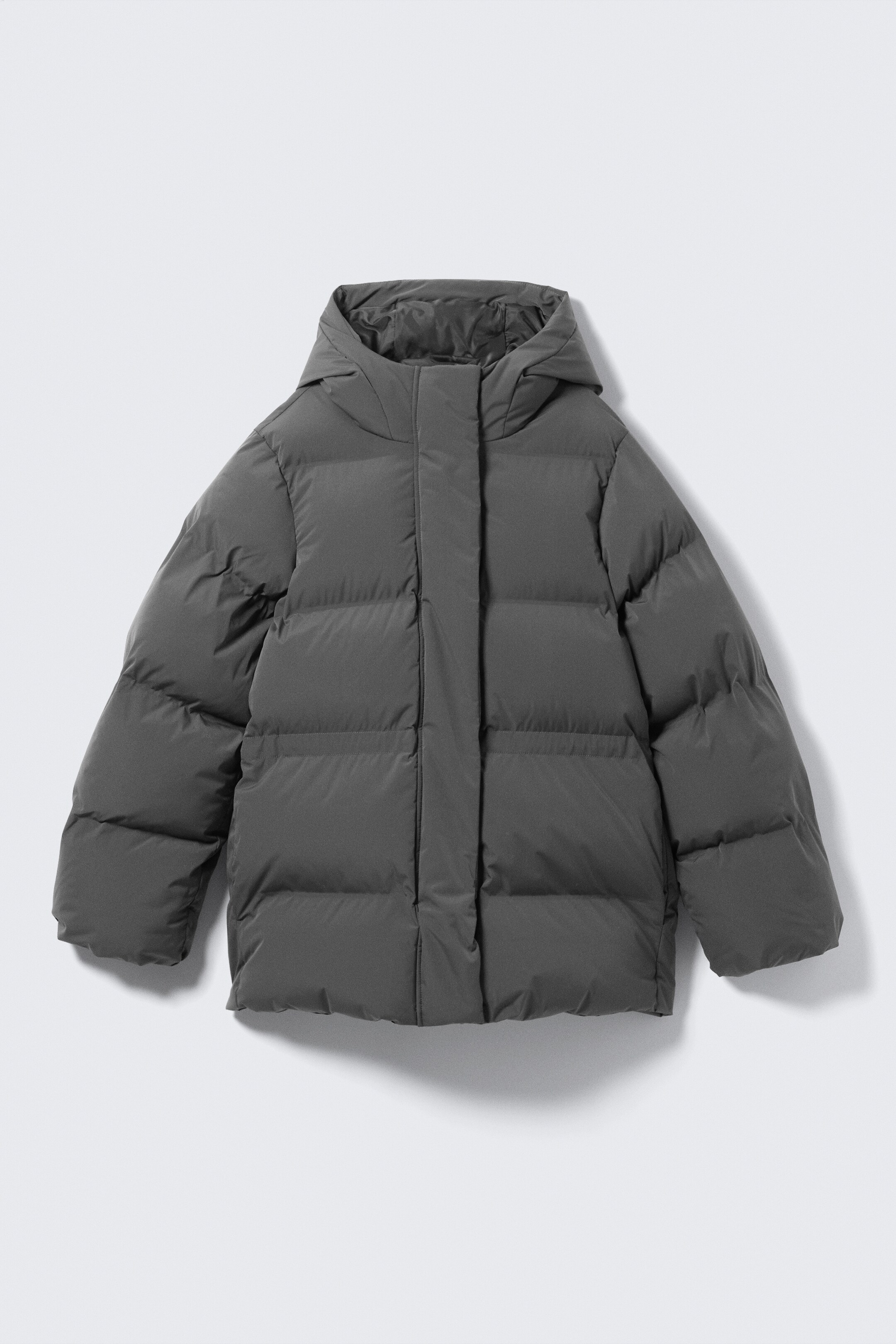 Größeres Bild anzeigen: Eine dunkelgraue taillierte Steppjacke wird von VORNE präsentiert, mit horizontalen Steppnähten über den Körper und die Ärmel, einer angesetzten Kapuze, einem hohen Kragen, einer durchgehenden Knopfleiste, die den zentralen Frontverschluss verdeckt, und dezenten vertikalen Seitentaschen.