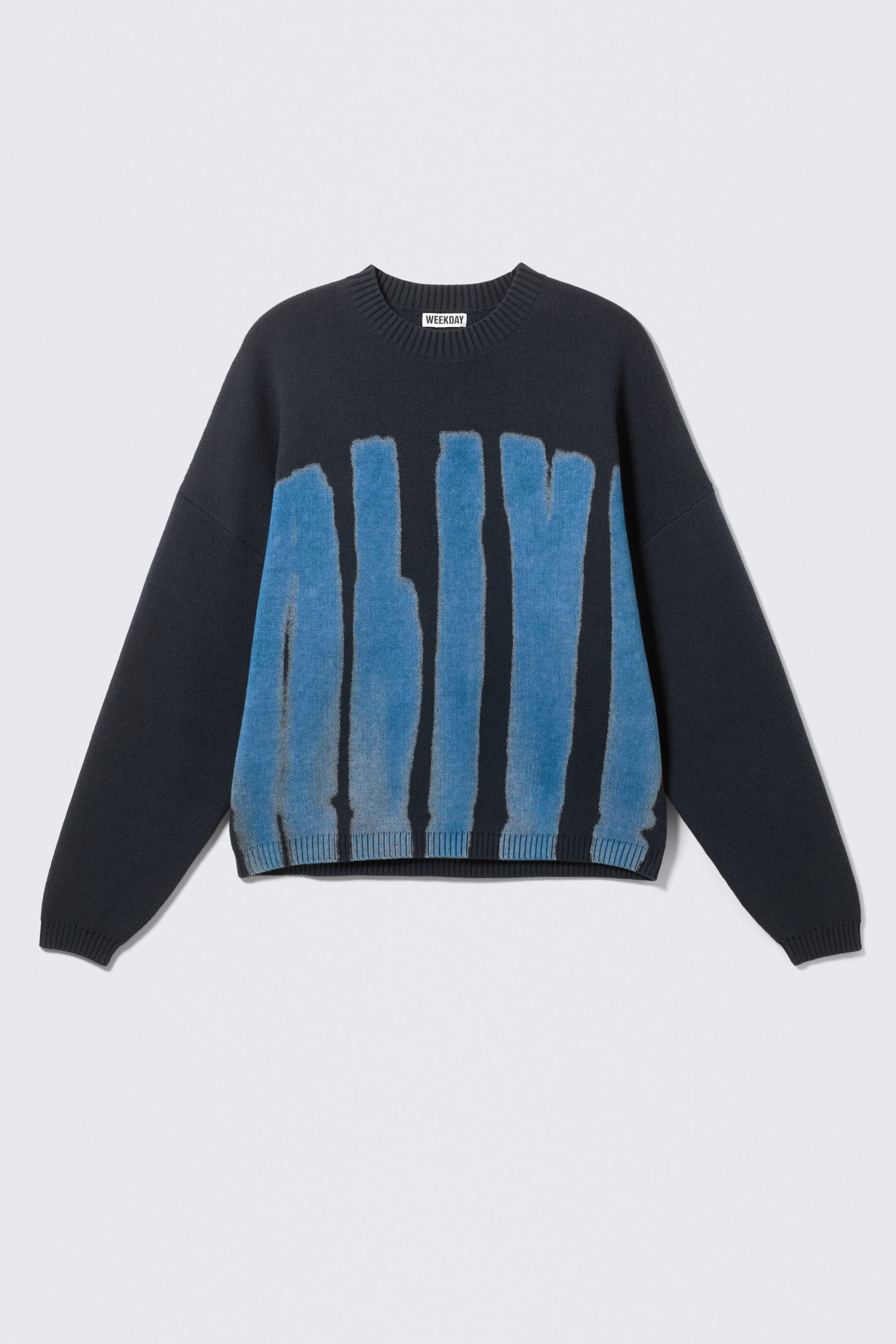 Grösseres Bild ansehen: Ein dunkelgrauer Strickpullover zeigt seine VORDERSEITE. Er zeichnet sich durch eine übergroße Passform mit überschnittenen Schultern, gerippten Abschlüssen und einem grafischen Druck mit blauen vertikalen Streifen über der Brust aus.