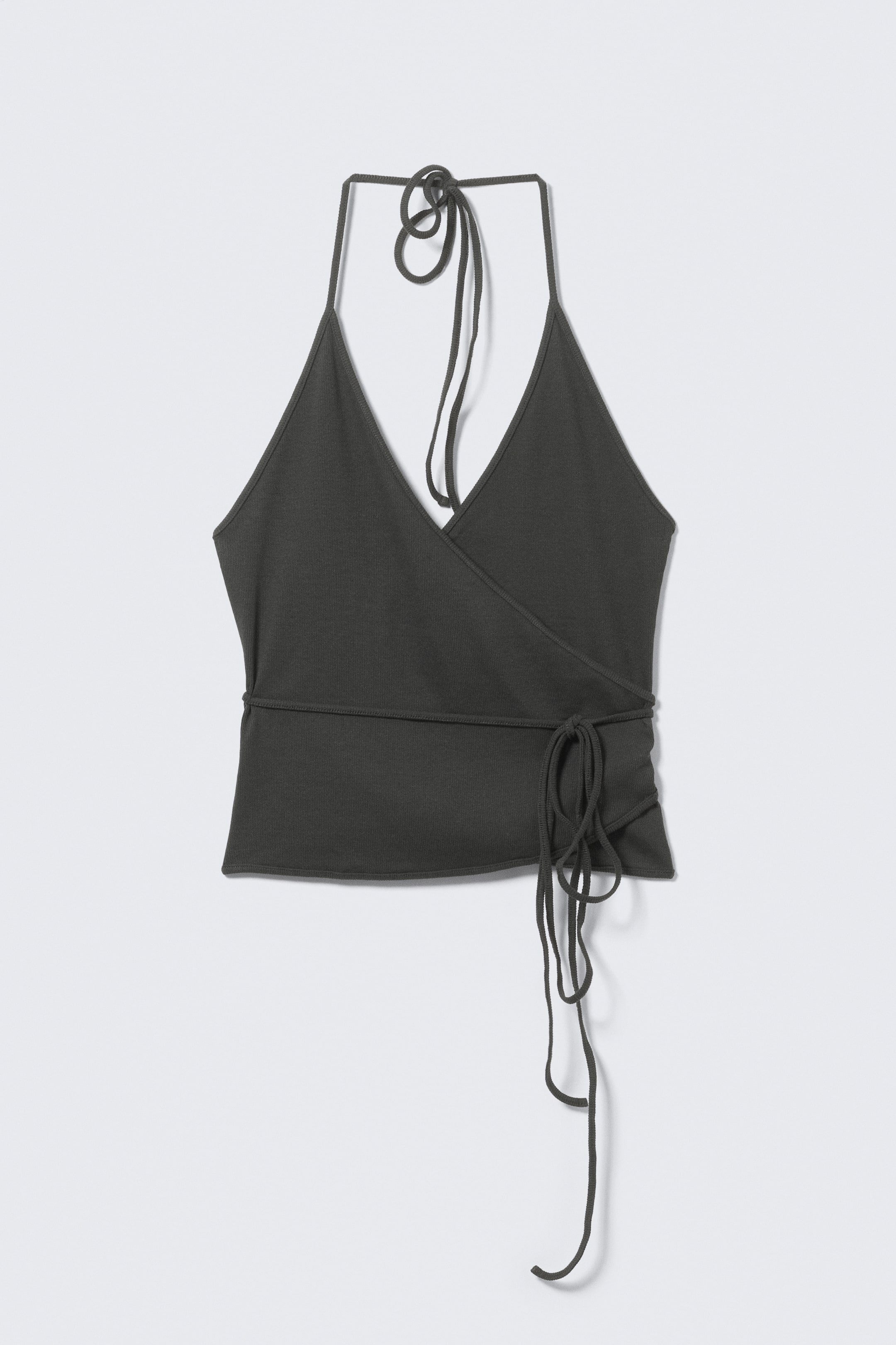 Se større billede: En mørkegrøn halterneck wrap-top, set forfra, har en dyb V-udskæring med tynde stropper, der bindes i nakken, og en taljebinding, der vikler sig rundt og knyttes i siden, hvilket skaber rynker langs kanten.