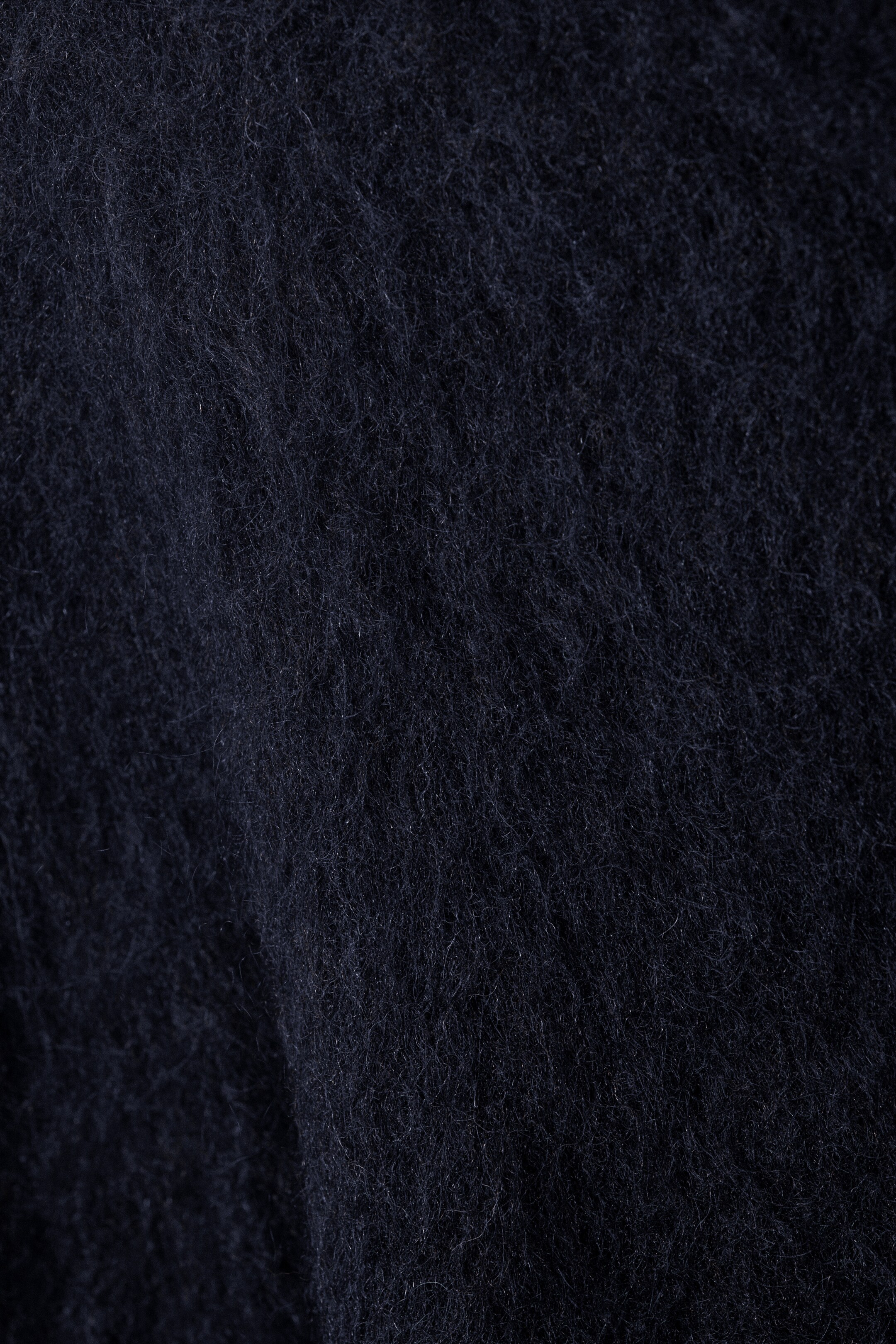 Größeres Bild anzeigen: Ein Nahaufnahmebild zeigt ein dunkelblaues Textil mit einer ausgeprägten flauschigen Textur. Die Oberfläche wirkt plüschig und weich, mit sichtbaren einzelnen Fasern, die einen gebürsteten Effekt erzeugen.