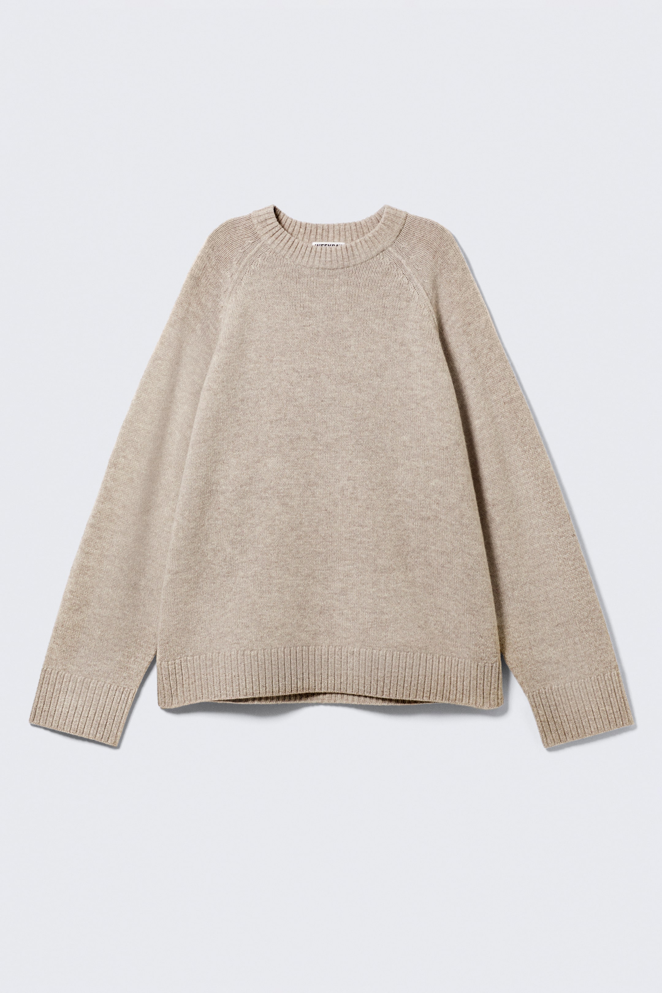Größeres Bild ansehen: Ein beiger Strickpullover wird vorne angezeigt, mit einer feinen Strickstruktur und einer entspannten Passform. Er hat einen Rundhalsausschnitt, Raglanärmel und breite gerippte Abschlüsse an den Bündchen und am Saum.