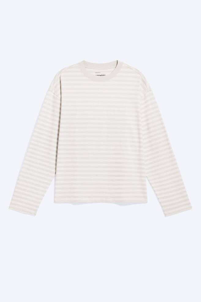 Un tricou cu mâneci lungi, croială boxy, este orientat spre față, afișând un model de dungi orizontale în nuanțe de bej deschis și alb murdar. Acesta are un gât rotund, mâneci lungi și un tiv drept, creând o potrivire lejeră. - 1