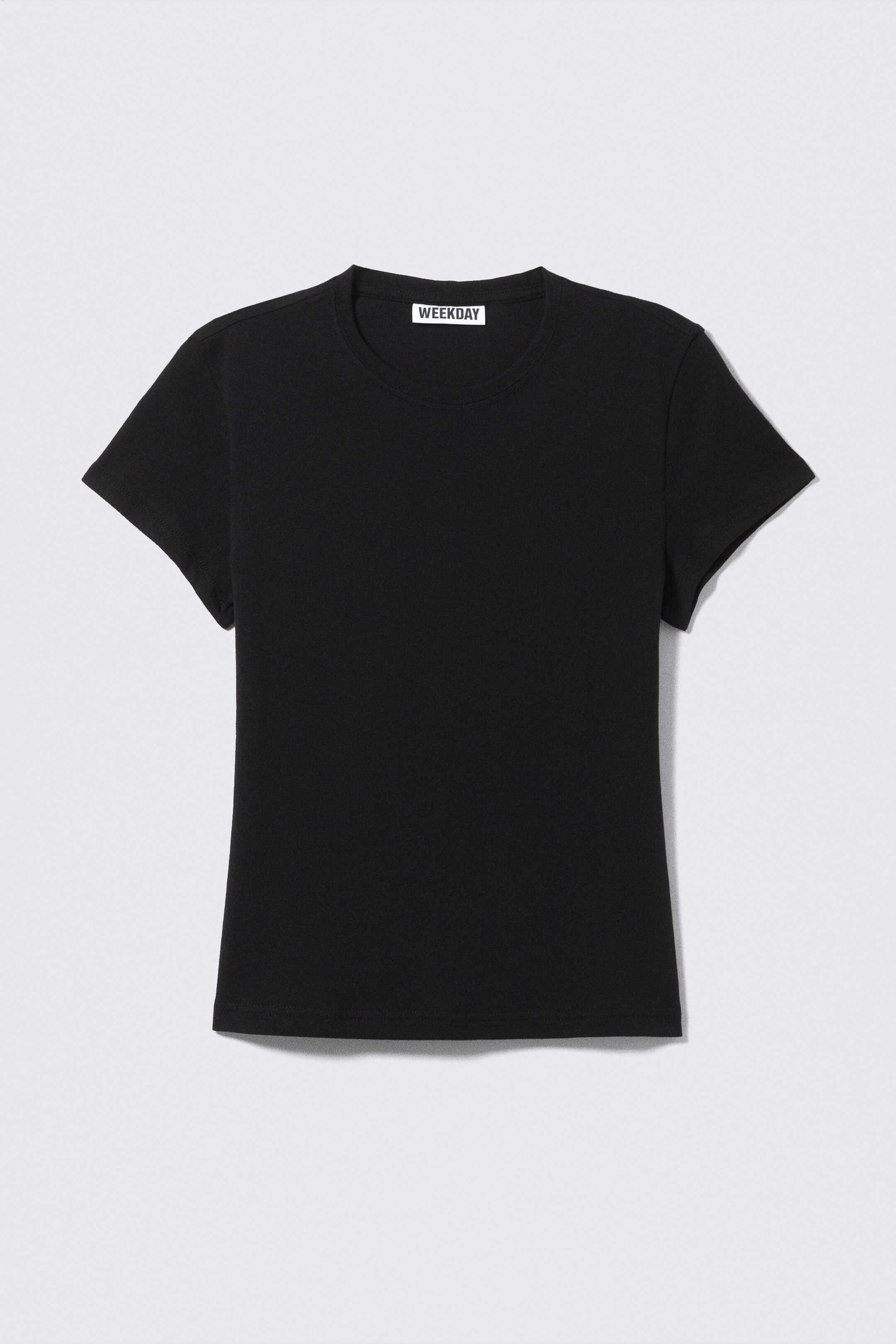 Größeres Bild ansehen: Ein schwarzes T-Shirt mit Rundhalsausschnitt präsentiert seine Vorderseite und weist kurze Ärmel sowie einen schlanken Schnitt auf. Ein „WEEKDAY“-Etikett ist im inneren Rückenausschnitt sichtbar, und saubere Doppeknstiche vollenden den Saum und den Halsauschnitt.