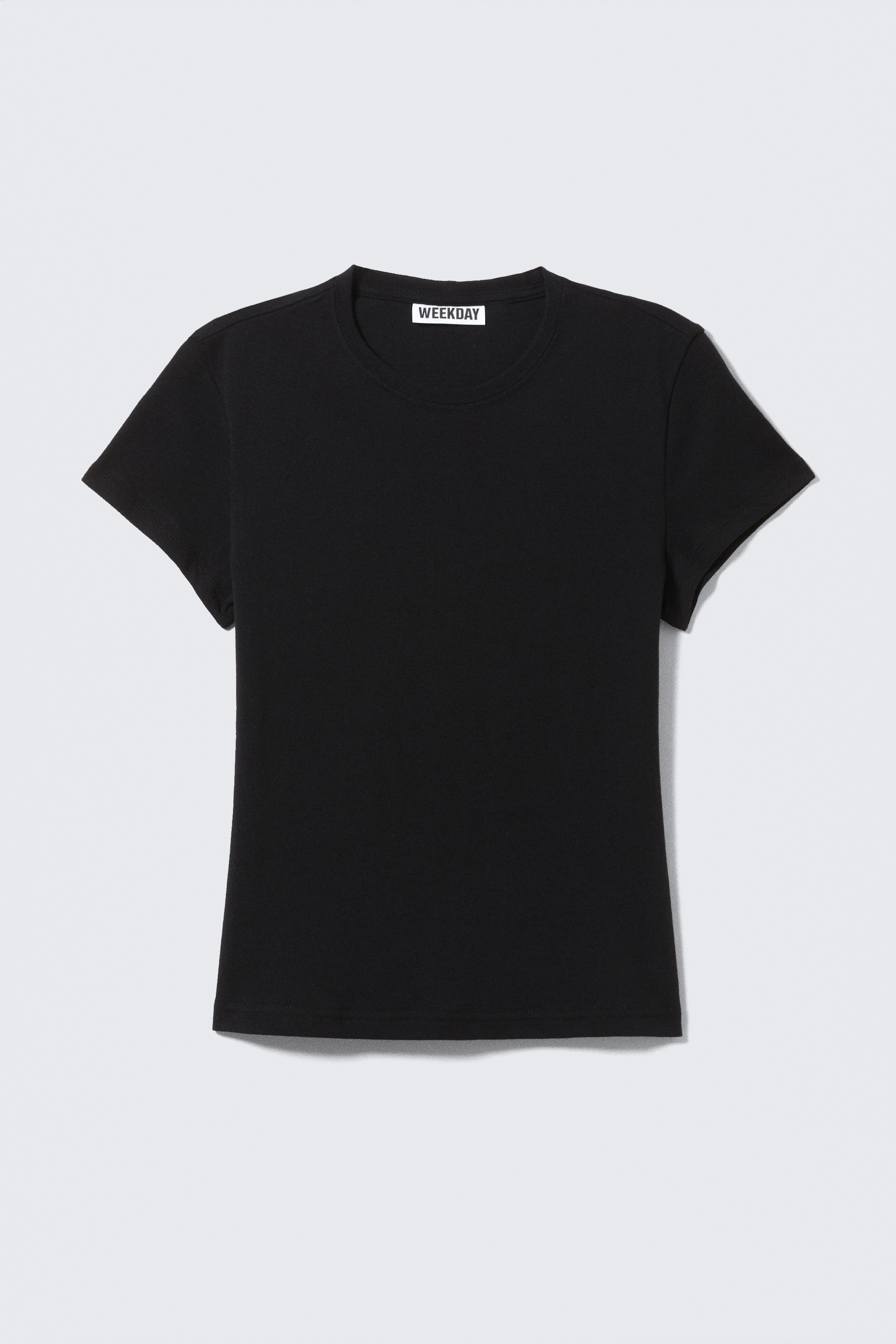 Grösseres Bild ansehen: Ein schwarzes T-Shirt mit Rundhalsausschnitt präsentiert seine Vorderseite, ausgestattet mit kurzen Ärmeln und einer schlanken Passform. Ein "WEEKDAY"-Etikett ist am inneren Rückenausschnitt sichtbar, und ein sauberer Doppelnadelstich vervollständigt den Saum und den Halsausschnitt.
