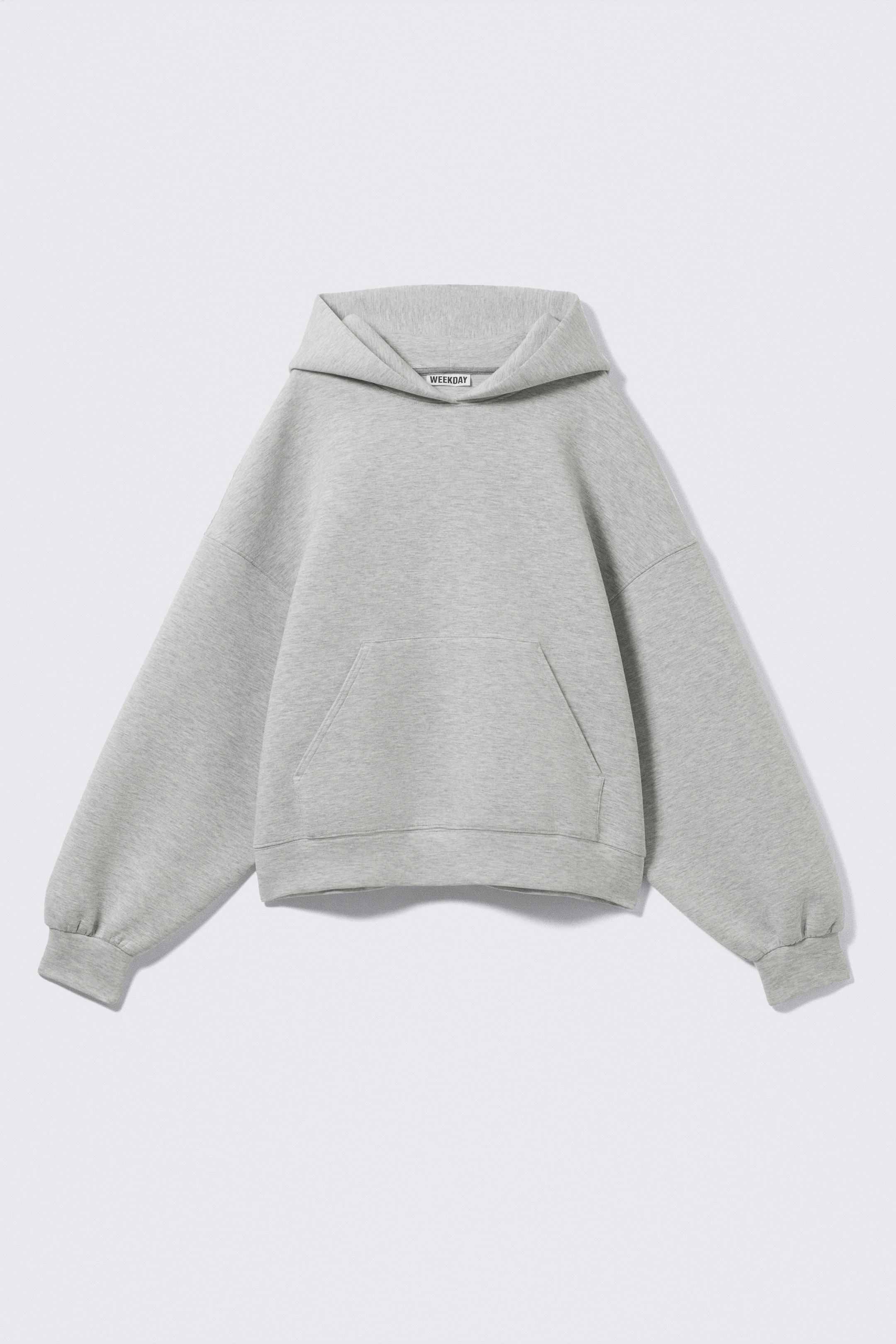 Visualizza immagine più grande: Una felpa grigia da subacqueo viene mostrata dalla parte anteriore, tagliata in una vestibilità oversize. Presenta un cappuccio spazioso, spalle cadenti, una tasca a marsupio e polsini e orlo lisci.