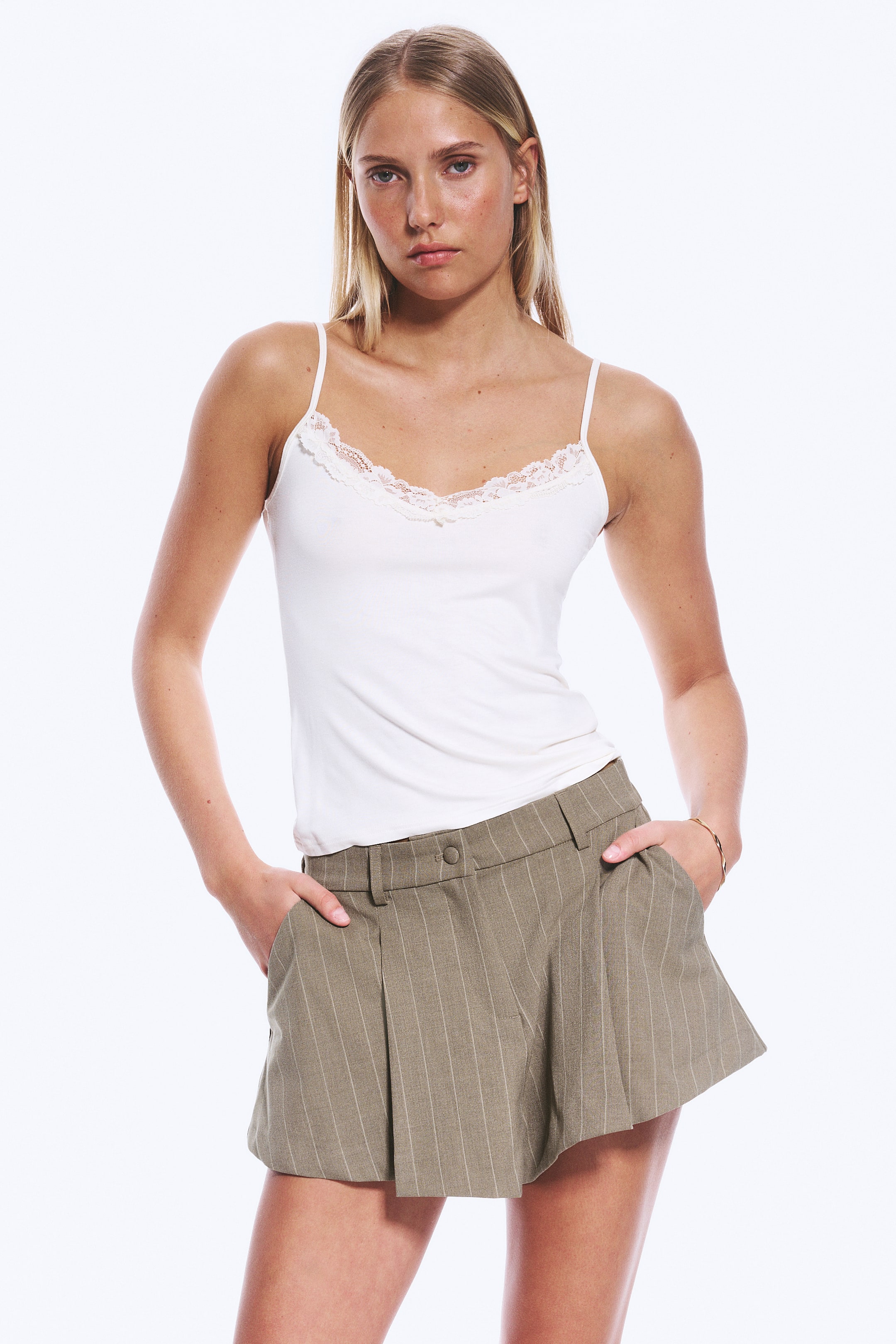 Grotere afbeelding bekijken: Khaki gestreepte shorts met een uitlopende, mini-lengte snit met voorplooien, zijzakken, een knoopsluiting en riemlussen in de taille, gezien vanuit een lichte voorhoek.