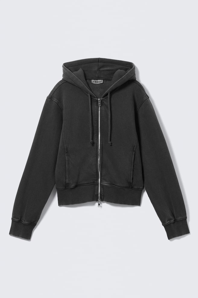 Una sudadera con capucha de cremallera en gris oscuro y desgastado se presenta de FRENTE, con una cremallera cerrada de tono plateado en el centro y una capucha con cordones visibles. También muestra dos bolsillos frontales, puños acanalados y un dobladillo acanalado. - 1