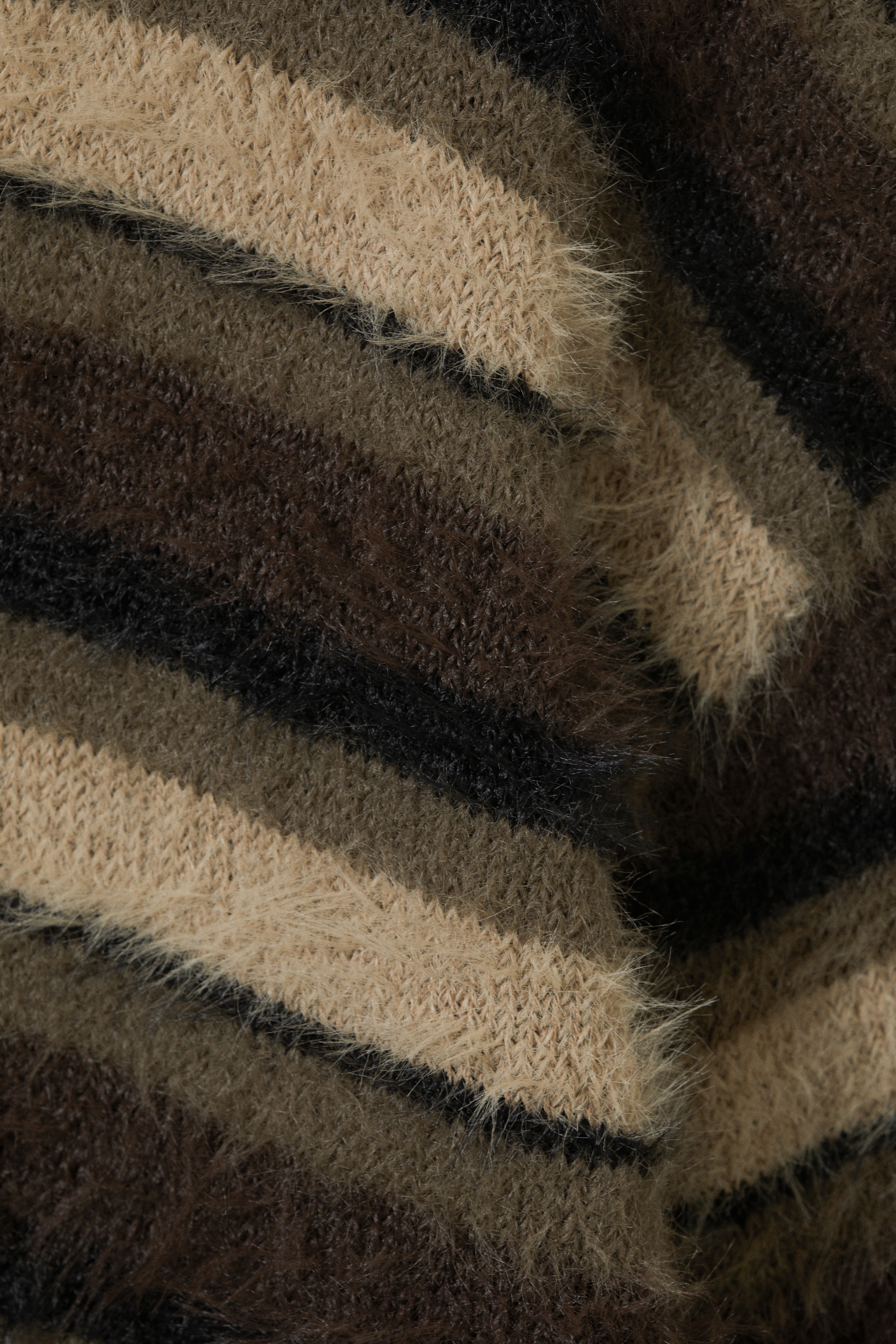 Visualizza immagine più grande: Un tessuto morbido presenta strisce orizzontali in diverse tonalità di marrone, nero e beige.