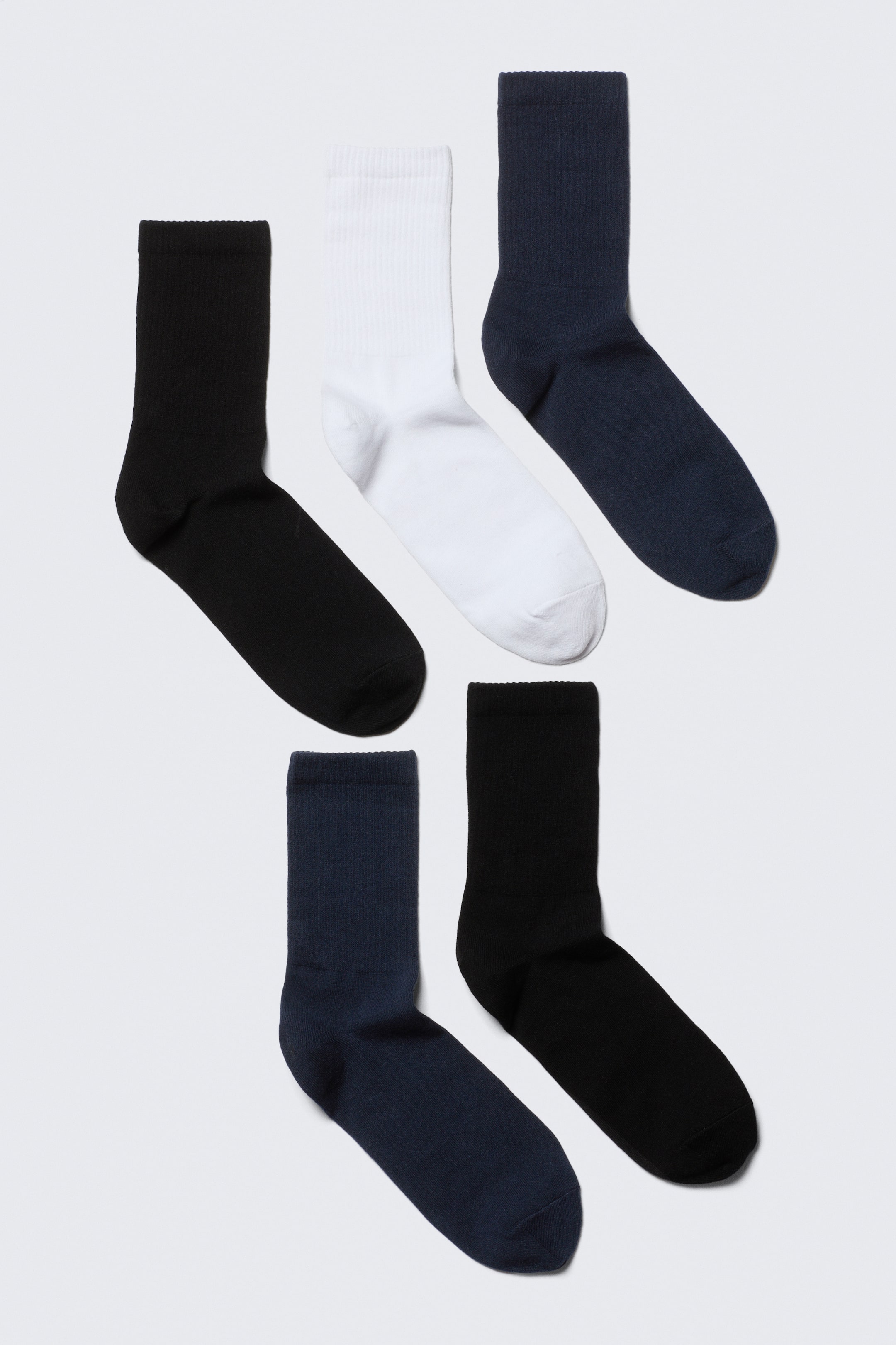 View larger image: A five-pack of sport mid-ankle socks is presented FRONT, featuring two black, two navy, and one white sock. Each sock displays ribbed ankles, a smooth instep, and reinforced toes.
