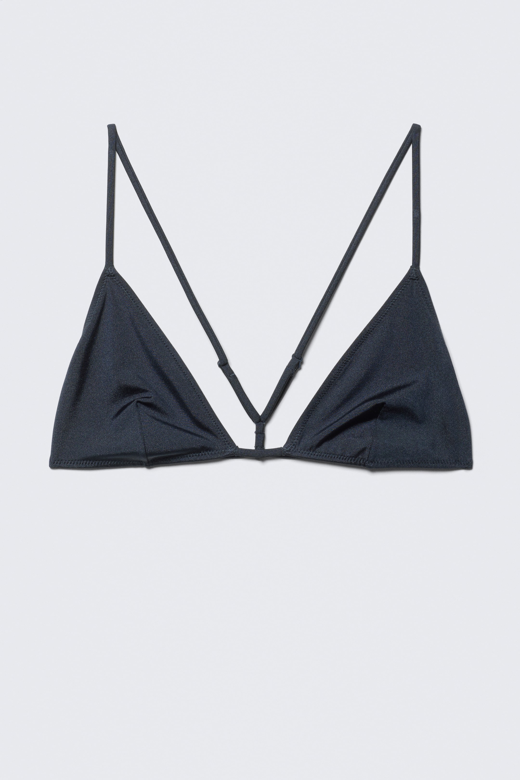 Agrandir l'image: Un haut de bikini triangle gris foncé est présenté de FACE. Il se compose de deux bonnets triangulaires avec des bretelles fines et ajustables formant un dos nageur, et une bande étroite relie les bonnets au centre inférieur.