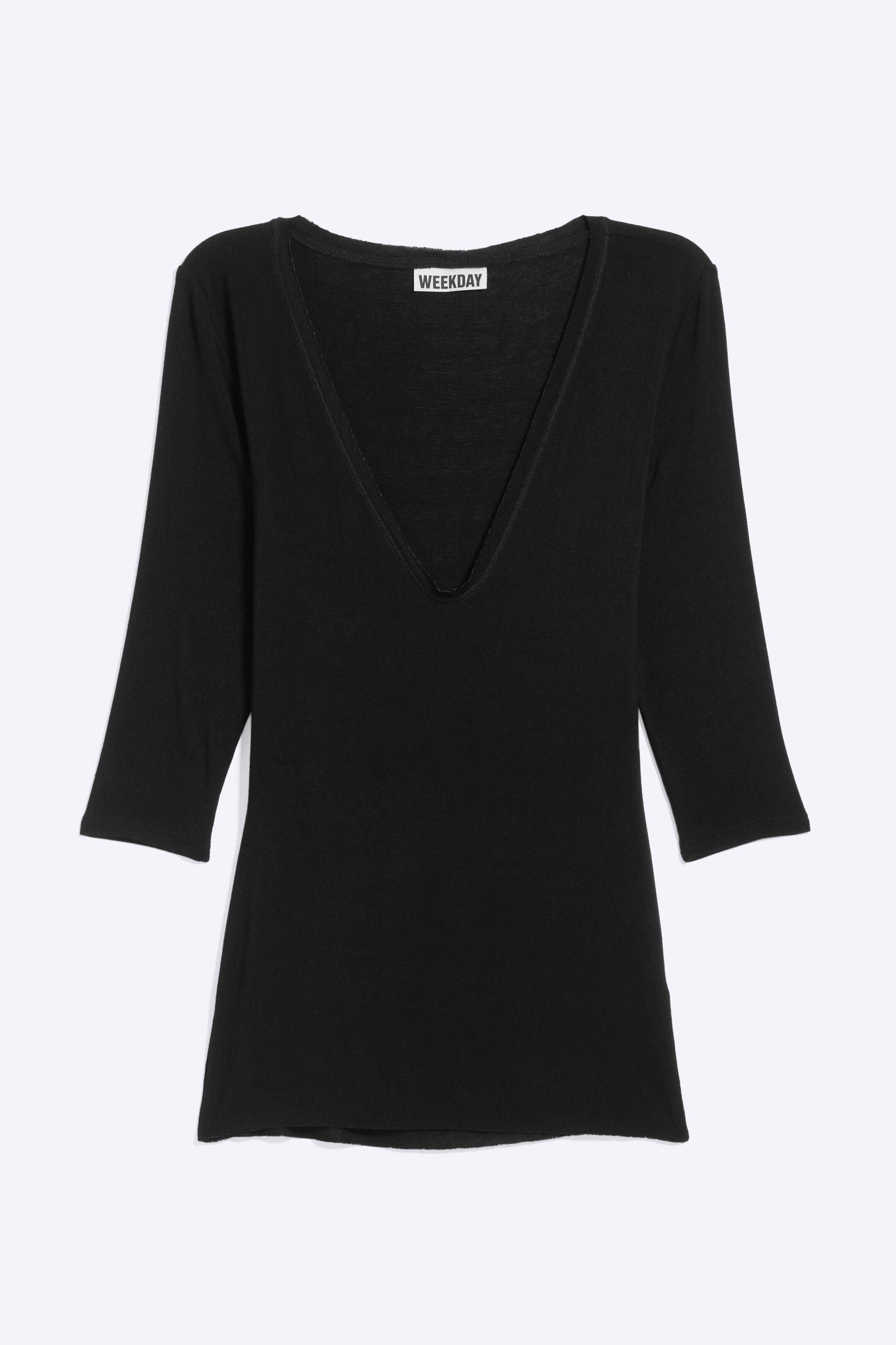 Ver imagen más grande: Un top negro con un escote en V profundo, mangas de tres cuartos y una etiqueta de la marca "WEEKDAY" visible en la parte posterior del escote.