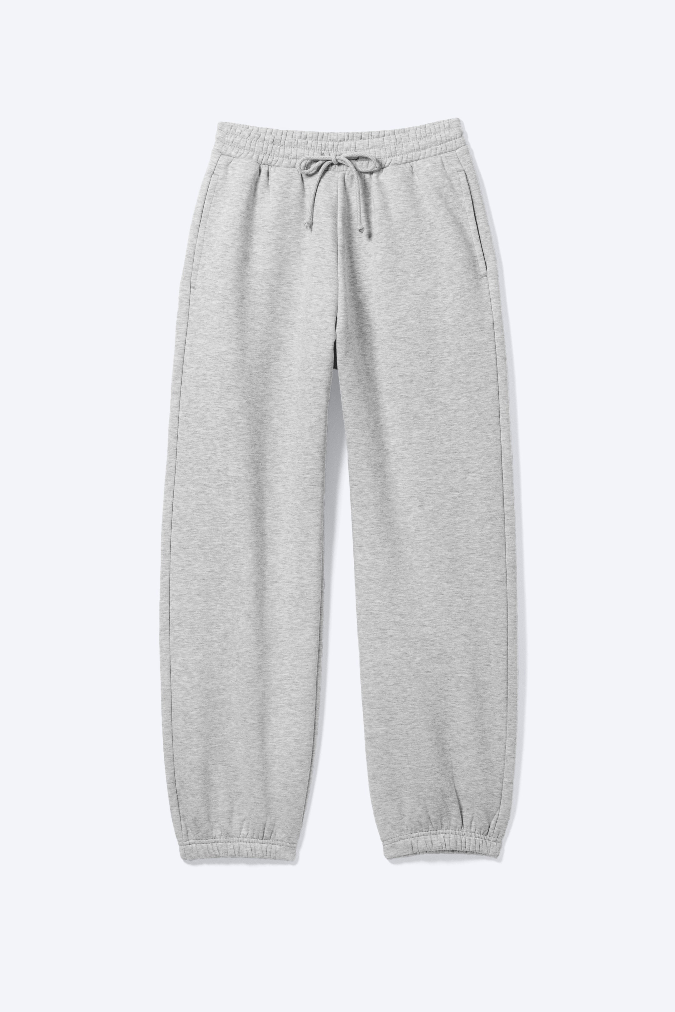 Grotere afbeelding bekijken: Lichtgrijze joggingbroek met een elastische tailleband met trekkoord gestrikt in een strik, subtiele zijzakken en elastische enkelboorden.