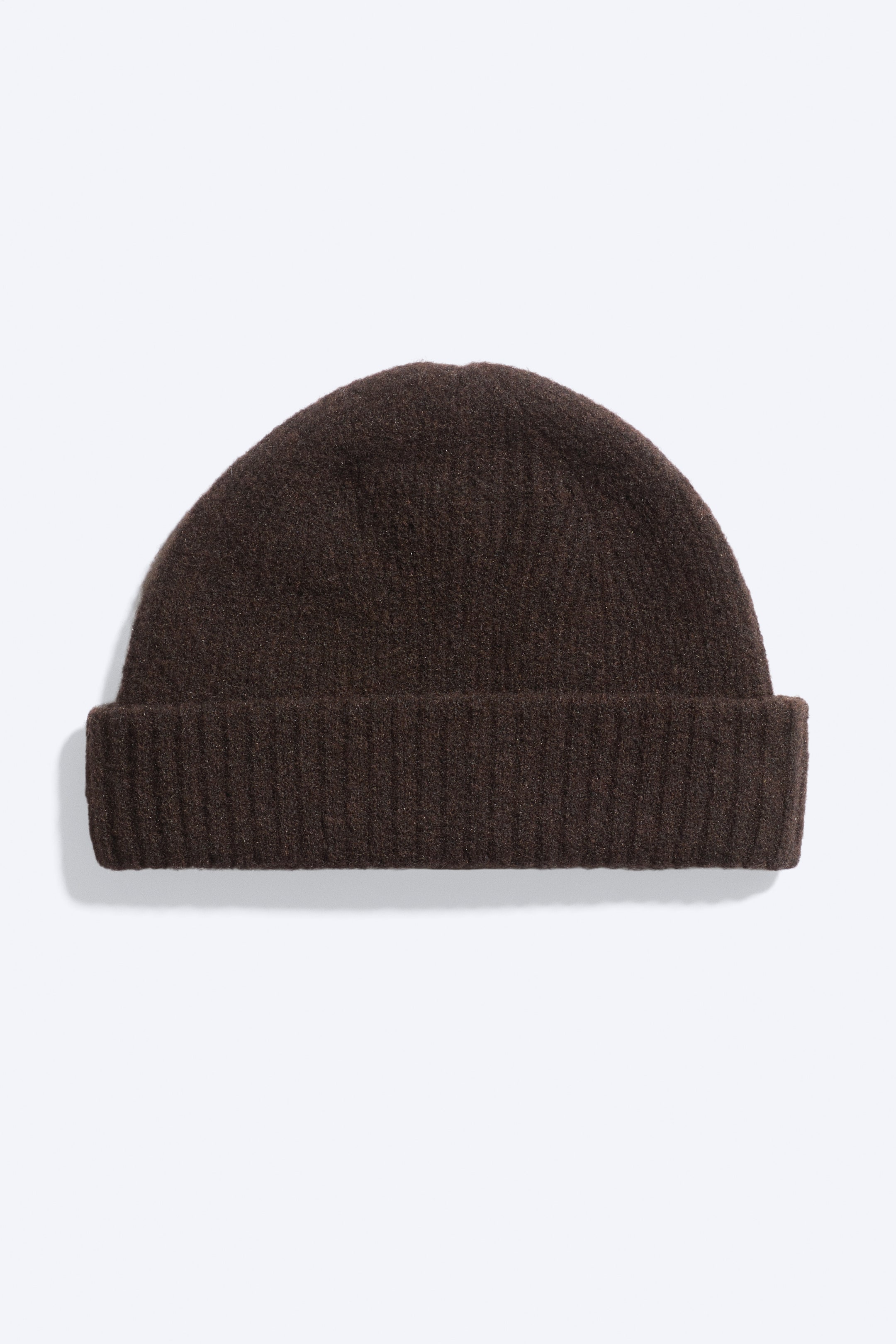 Agrandir l'image: Un bonnet tricoté marron foncé, vu de face, avec une construction texturée en mélange de laine, une forme arrondie ajustée et un large revers côtelé replié.