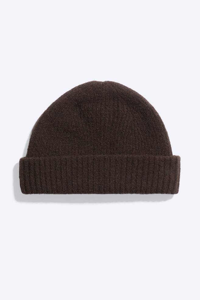 Eine dunkelbraune StrickmÃ¼tze von vorne, mit strukturierter Wollmischung, einer abgerundeten, eng anliegenden Form und einem breiten, umgeschlagenen Rippenbund. - 1