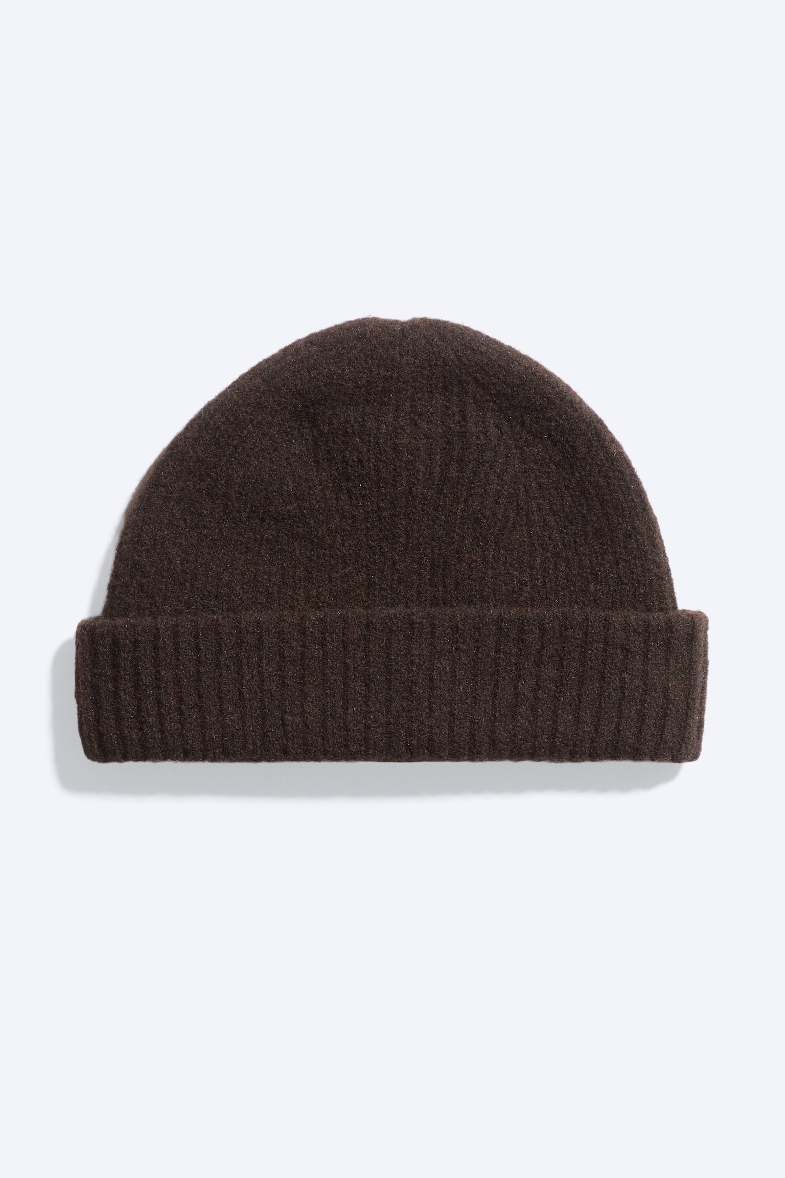 Un bonnet en maille brun foncé, vu de face, présentant une confection texturée en mélange de laine, une forme arrondie ajustée, et un large revers côtelé replié.