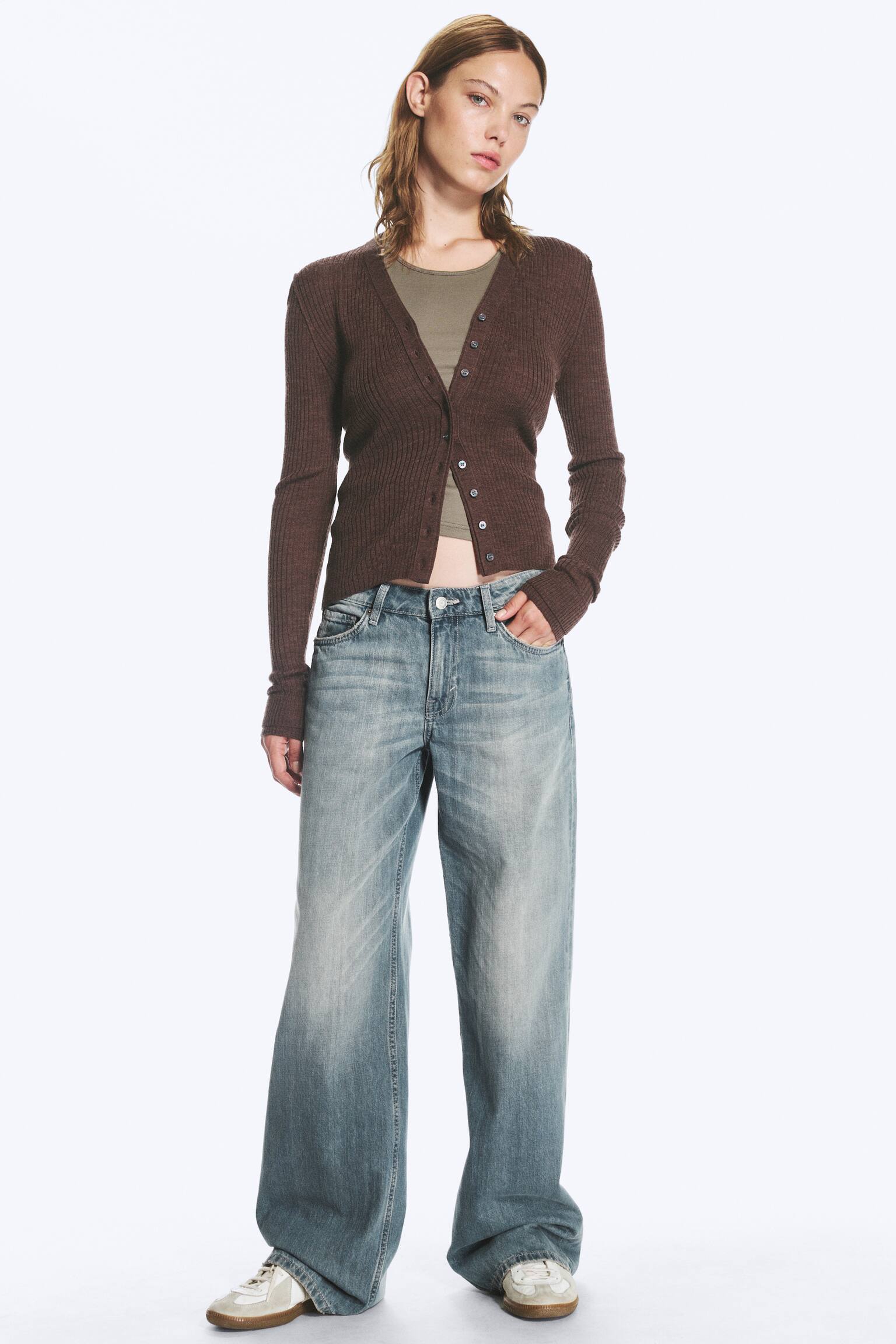 Un paio di jeans a vita bassa azzurri viene presentato come FRONT, caratterizzato da una vestibilità ampia e una gamba larga e lunga in denim rigido. I jeans mostrano un classico design a 5 tasche con zip visibile e presentano un lavaggio scolorito, più chiaro sulle cosce. - 1