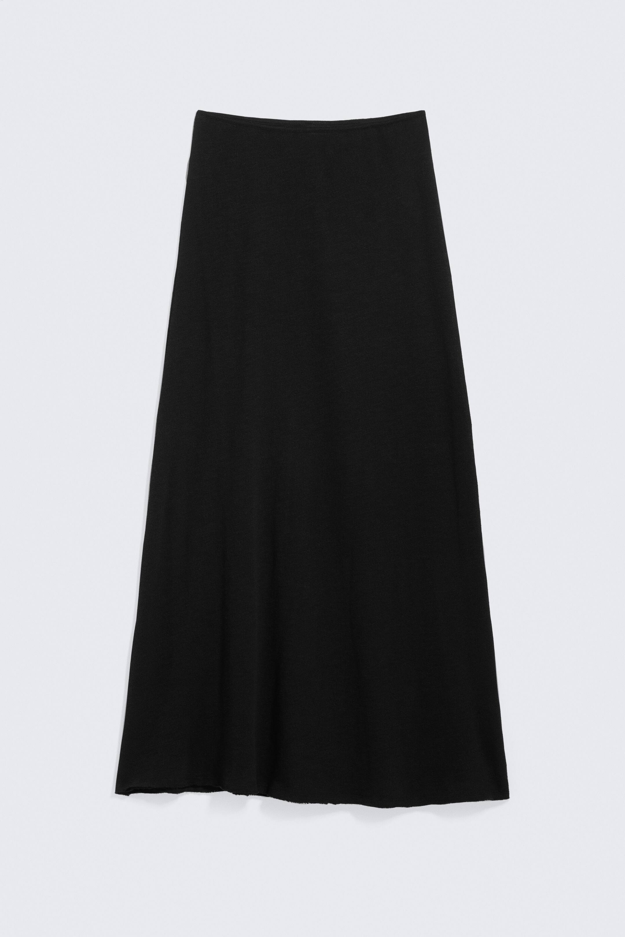 Vezi imaginea mai mare: O fustă maxi tricotată de culoare neagră este prezentată din față, având o siluetă ușor evazată și o textură subtilă a materialului. Este finisată cu un tiv neprelucrat.