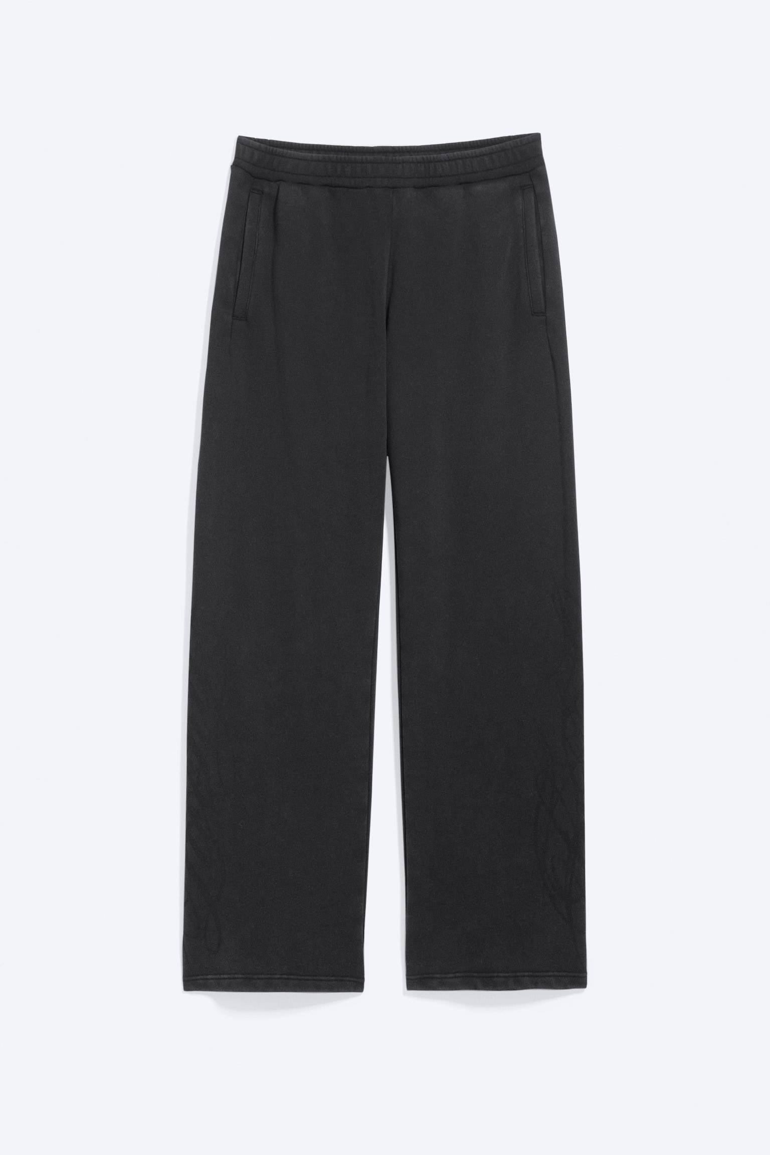 Ein Paar dunkelgrauer Sweatpants mit geradem Bein ist in einer Flat-Lay-PrÃ¤sentation von vorne zu sehen. Die Sweatpants verfÃ¼gen Ã¼ber einen elastischen Bund, vertikale seitliche Leistentaschen und ein dezentes, tonales Grafikdesign, das nahe den unteren BeinabschlÃ¼ssen aufgedruckt ist.