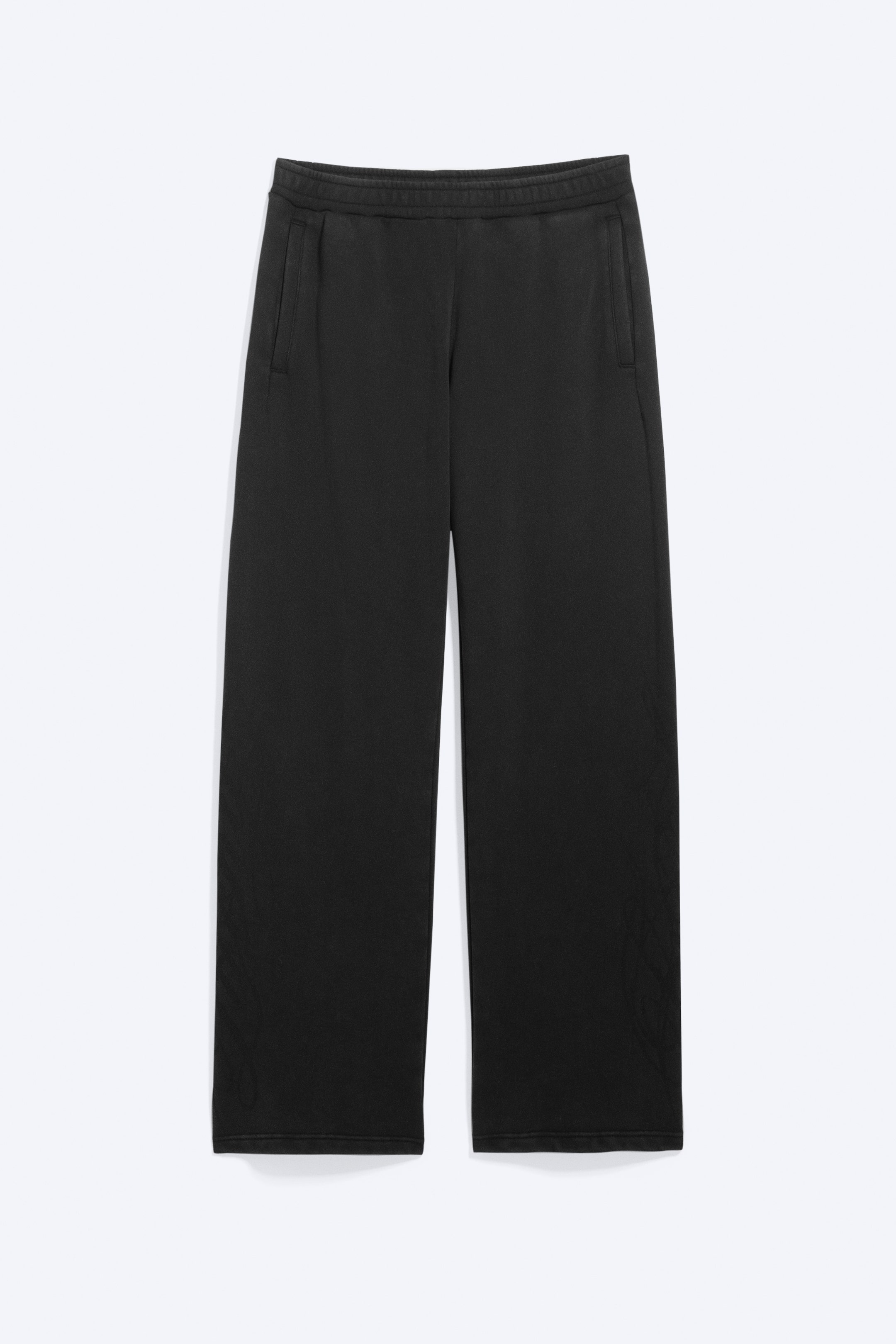 View larger image: A pair of dark grey, straight-leg sweatpants is shown front-facing in a flat-lay presentation. The sweatpants feature an elasticated waistband, vertical side welt pockets, and a subtle tonal graphic design printed near the lower hems.