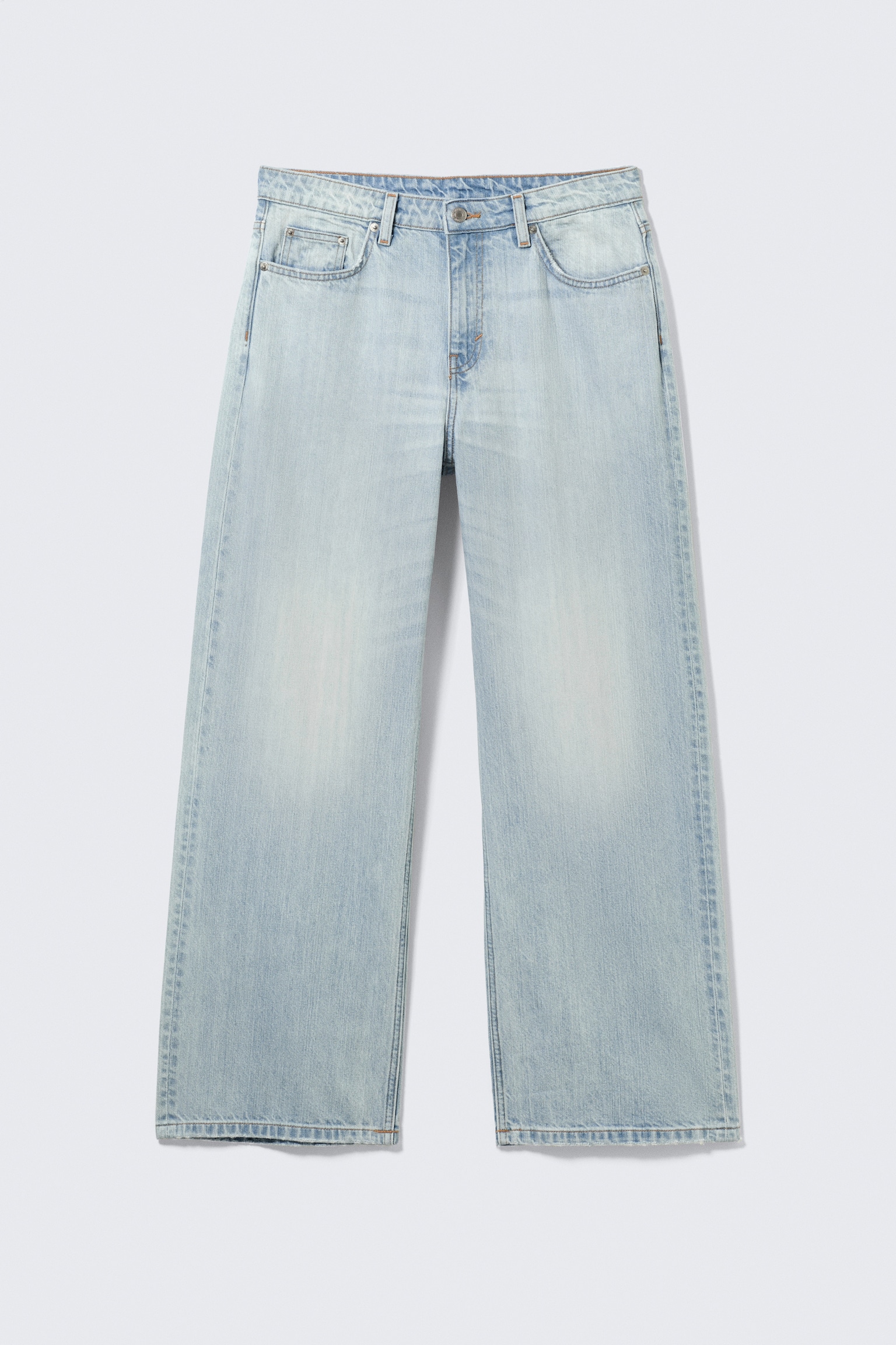 Ein Paar hellblaue, ausgewaschene Low-Rise-Jeans sind von vorne zu sehen, mit lockerem Schnitt und geradem Bein. Sie sind aus festem Denim gefertigt und verfügen über ein klassisches Fünf-Taschen-Design, einen Reißverschluss und großzügig geschnittene Beine.