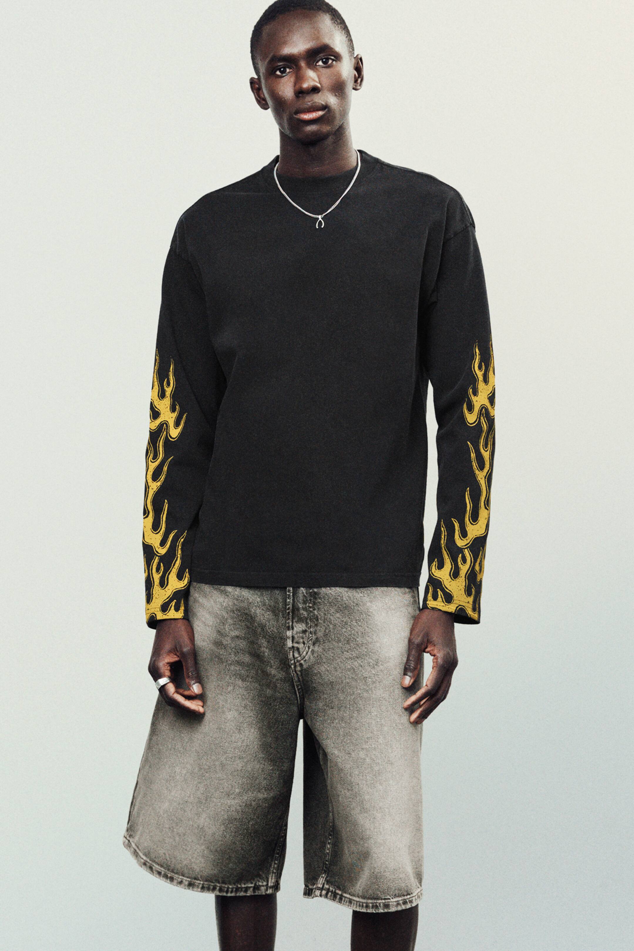 Agrandir l'image: Short en denim gris à taille mi-haute avec une coupe ample et décontractée portés par le mannequin. Ces shorts présentent un design classique à cinq poches et des ourlets repliés.