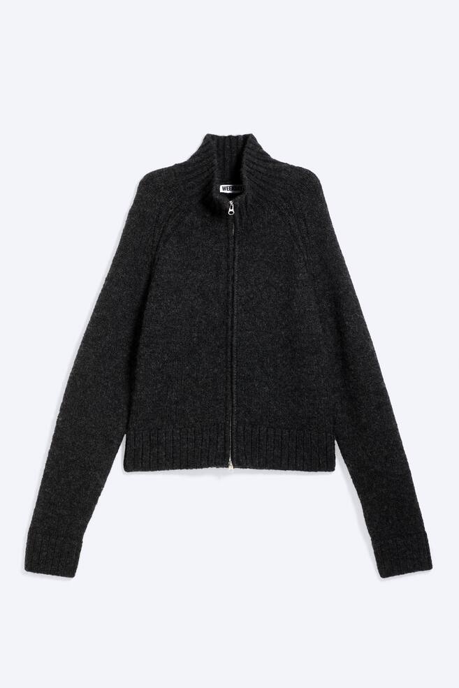 Un cárdigan de punto gris oscuro con cremallera se presenta de frente, con un tejido texturizado, mangas raglán y un cuello alto acanalado. Está diseñado con un cierre central de cremallera que muestra una etiqueta 'WEEKDAY', puños anchos acanalados y un dobladillo acanalado. - 1