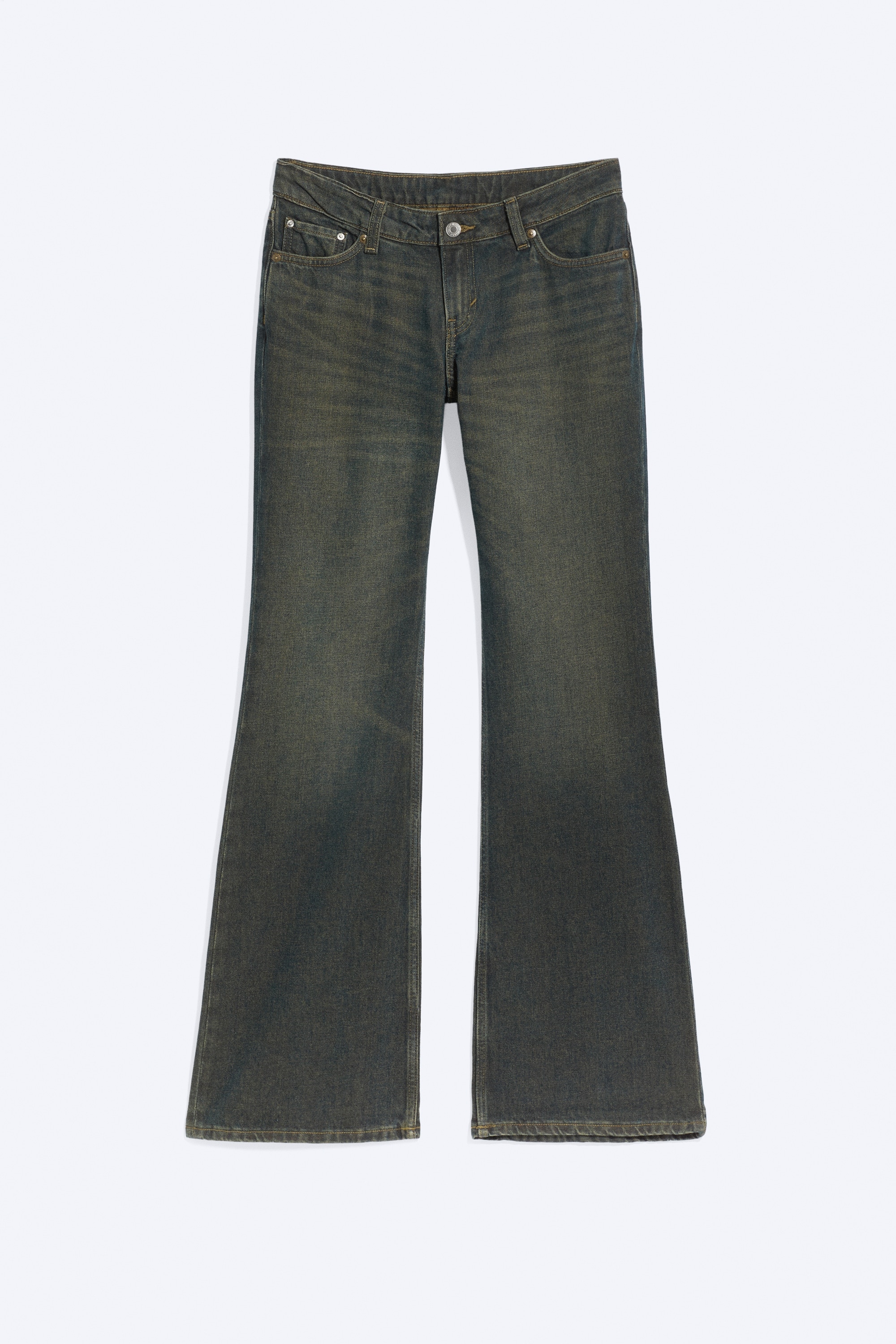 De jeans met lage taille in donker gewassen, gemêleerde denim worden gedragen door het model en hebben een slim fit rond de dijen met een lange, uitlopende bootcut-pijp. De jeans, uitgevoerd met de klassieke vijfzakkenstijl, worden gecombineerd met een olijfgroen jack met knopen en donkere schoenen.