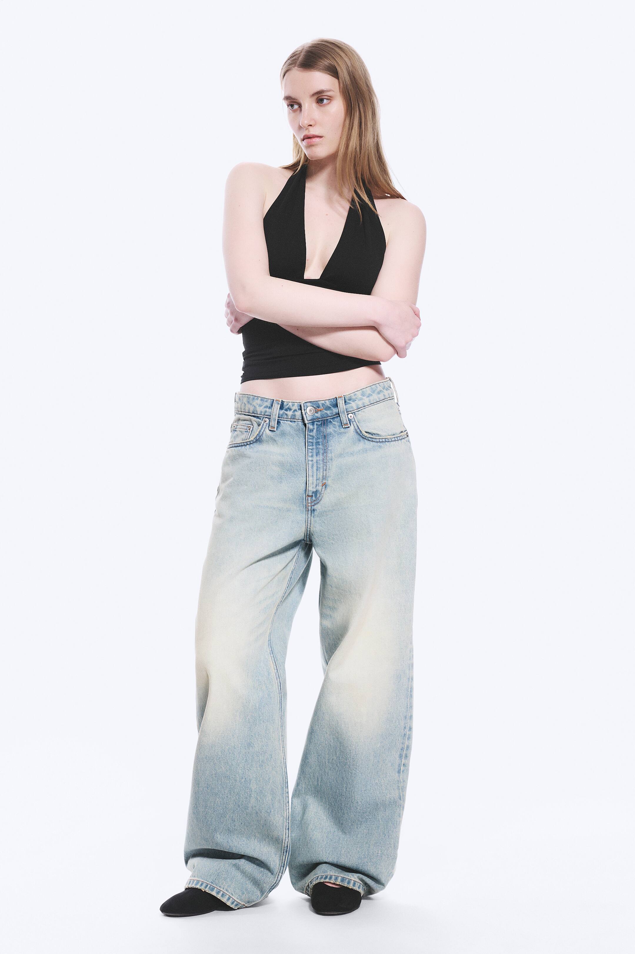 View larger image: A black halter top featuring a deep V-neckline and a fitted, cropped silhouette, showcased from the front.