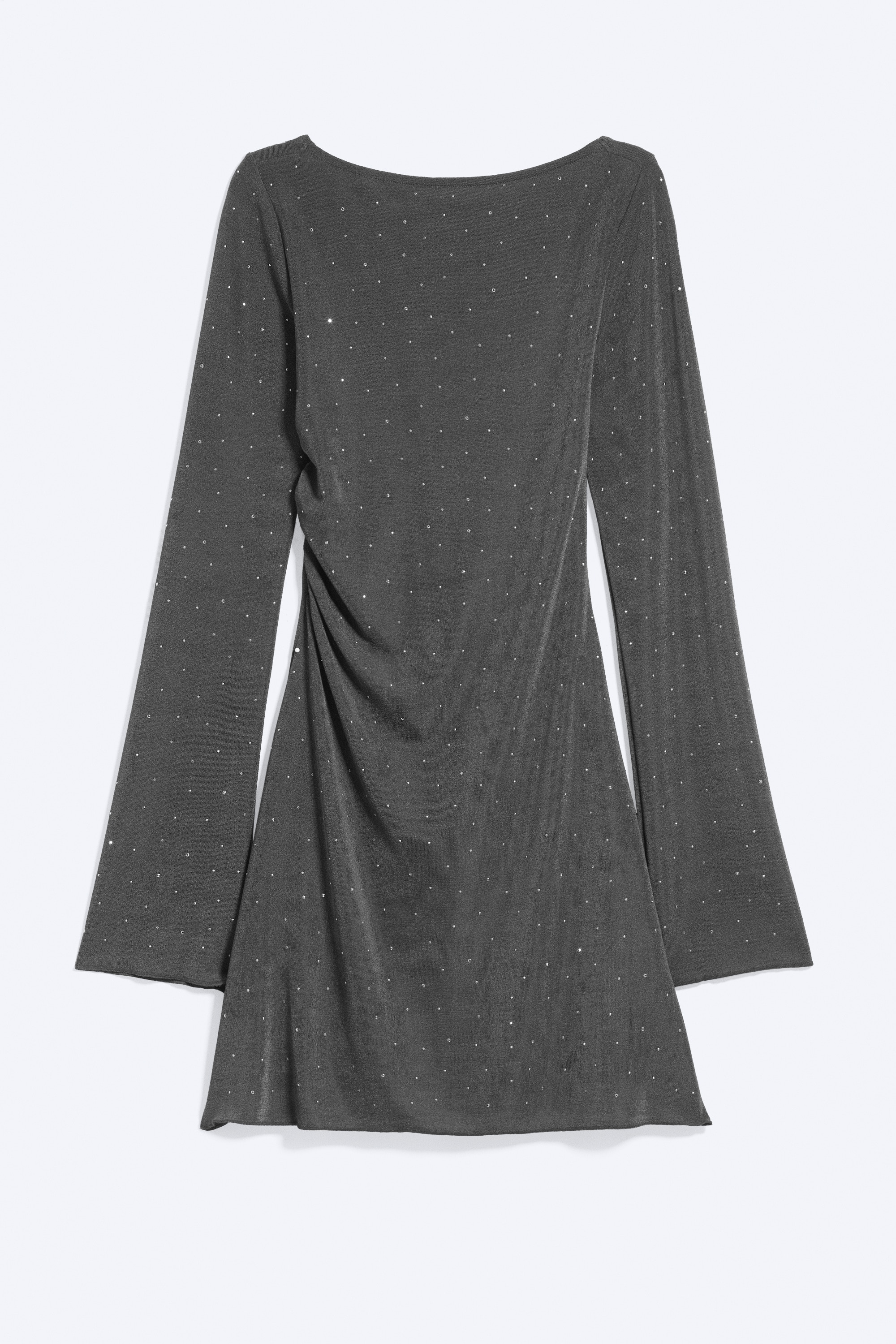 A dark grey, shimmering mini dress featuring a deep open back with a narrow tie fastening is being worn by the model. The dress is designed with long, slightly flared sleeves and a slim-fit silhouette, shown from a rear angle to highlight the open-back detail.