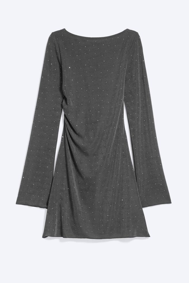 Ein dunkelgraues Minikleid ist von vorne zu sehen und zeigt einen U-Boot-Ausschnitt, lange ausgestellte Ãrmel und auf einer Seite geraffte Drapierungen. Der Stoff schimmert mit kleinen, verstreut auf dem gesamten KleidungsstÃ¼ck angebrachten Strasssteinen. - 1