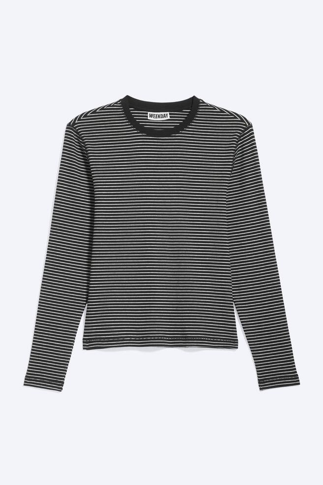 A long-sleeved t-shirt is shown from the front, featuring a black and white horizontal stripe pattern, a crew neckline, and a subtle ribbed texture. It presents a slim silhouette, with a "WEEKDAY" brand tag visible at the back of the neck. - 1