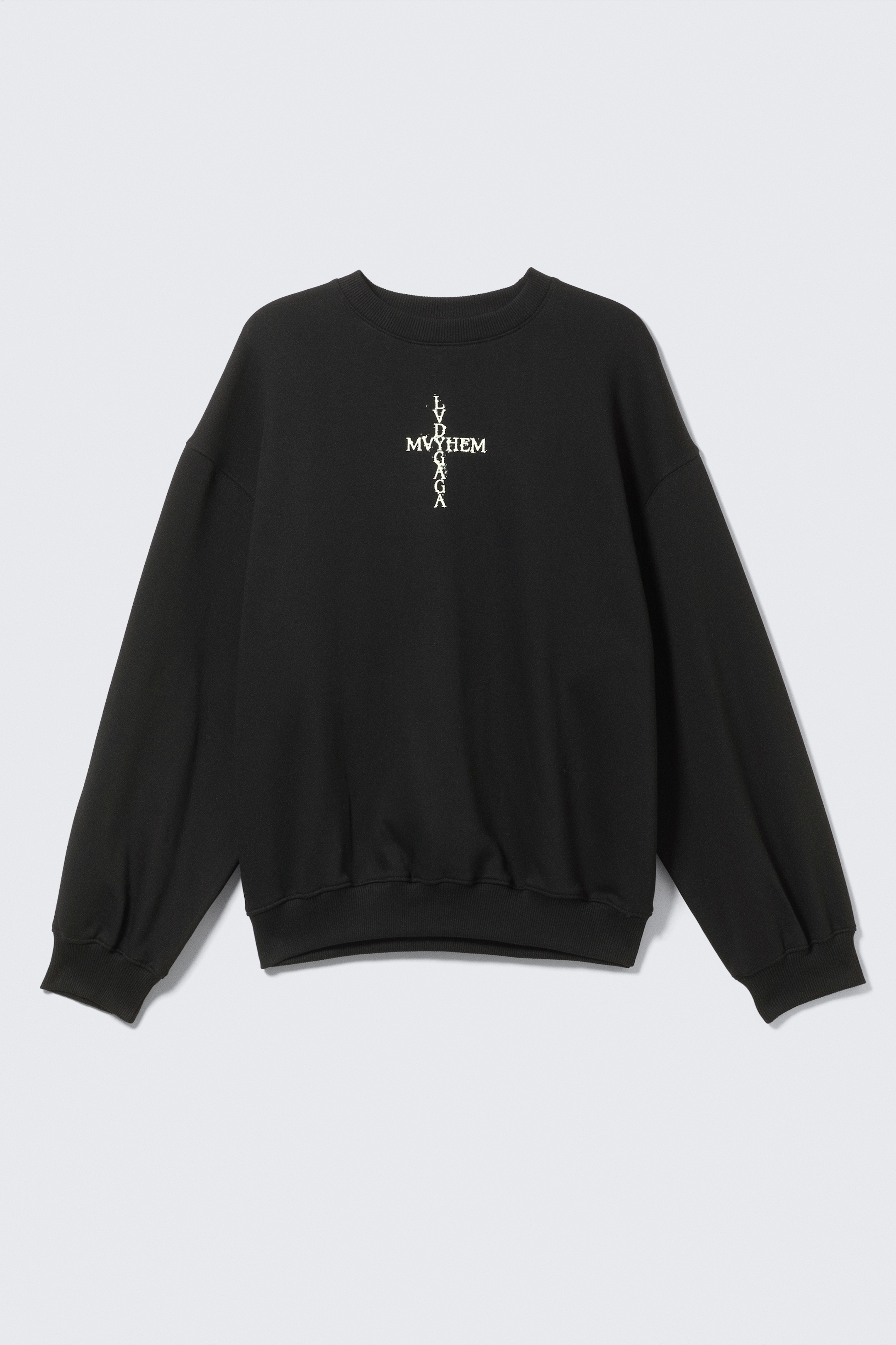 Agrandir l'image: Un sweat-shirt noir à col rond présente une coupe décontractée et surdimensionnée, avec des poignets, un col et un ourlet côtelés. Il présente un graphique blanc sur la poitrine formant une croix à partir de texte, lisant 'MVYHEM' horizontalement et 'LVDGAGA' verticalement.