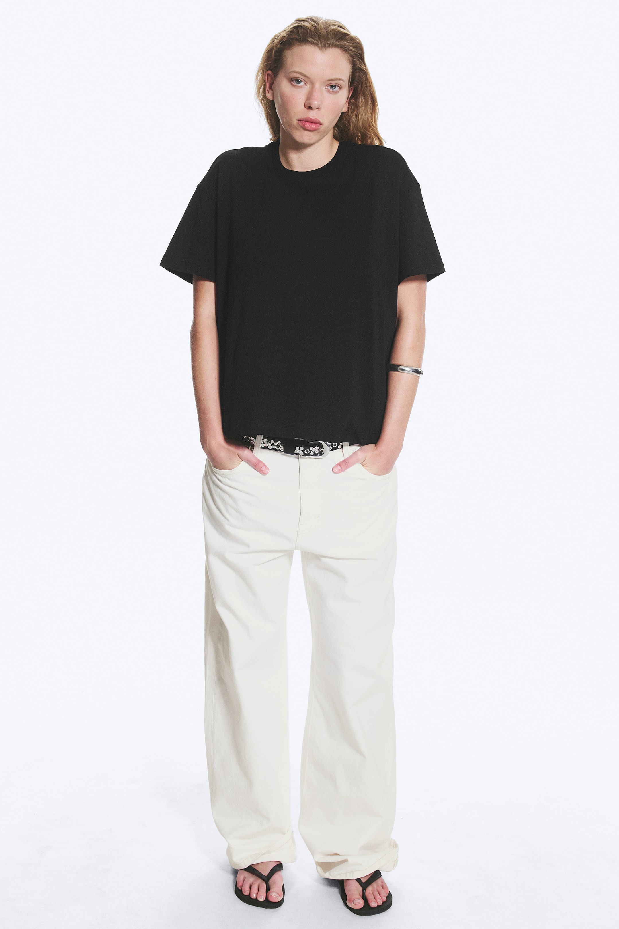 Visualizza immagine più grande: Una t-shirt nera oversize presenta un girocollo e maniche corte e larghe con spalle scese. Offre una vestibilità rilassata e un orlo dritto, rivolto in avanti.