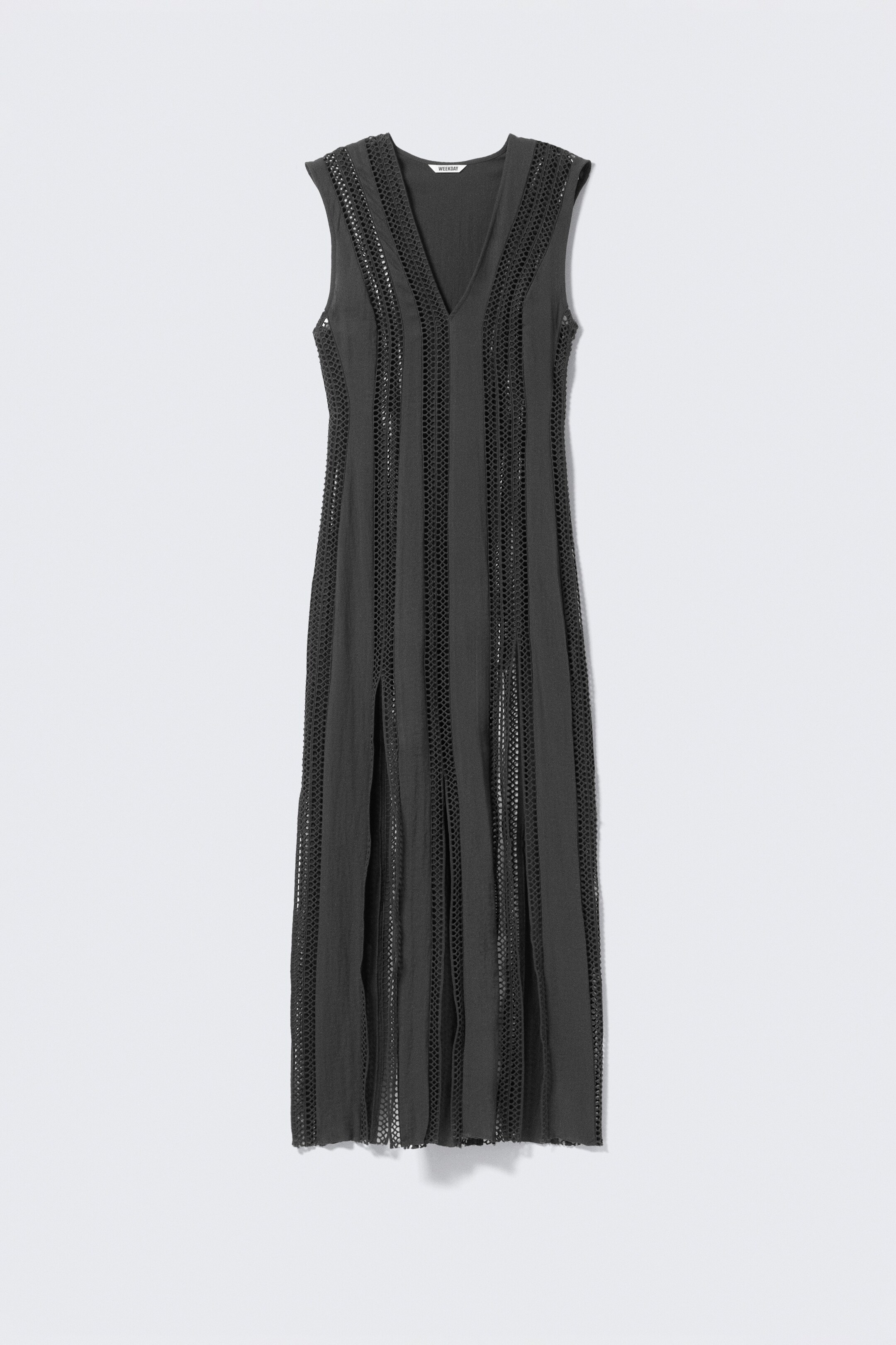 Agrandir l'image: Une robe maxi sans manches, présentée de FACE, est conçue avec un profond décolleté en V et une silhouette mince et allongée. Des panneaux de tulle ton sur ton et en transparence courent verticalement tout au long de la robe, qui présente deux fentes à l'avant s'étendant depuis l'ourlet et une finition à bord brut.