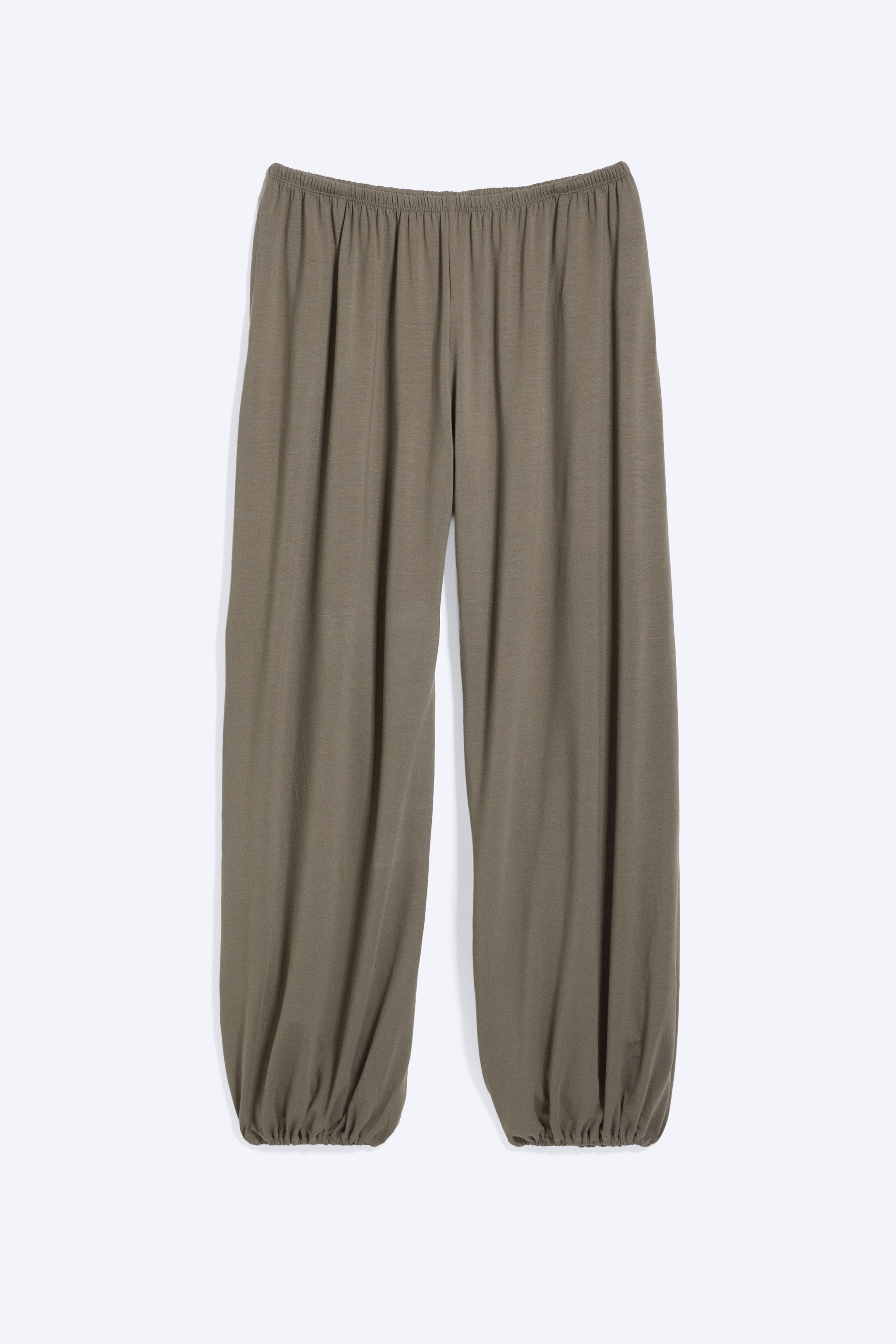 Vezi imaginea mai mare: O pereche de pantaloni cu croială lejeră este prezentată din față, având o talie elastică de înălțime medie. Pantalonii prezintă picioare largi, în formă de balon, care se strâng la manșete elastice, completând o siluetă voluminoasă.